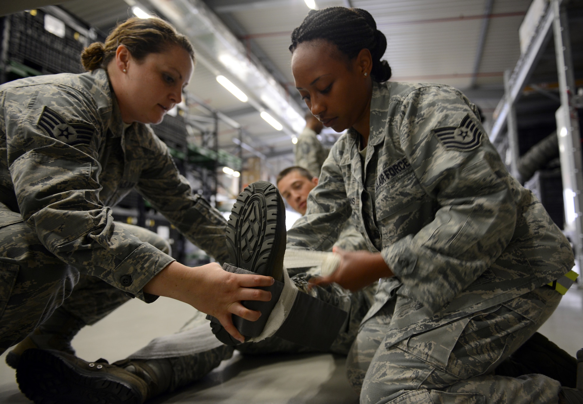 Staff Sgt. Lacy Owens, 86th Medical Operations Squadron medical technician, assists Tech. Sgt. Ambree Evans, 86th Aerospace Medical Squadron bioenvironmental technician, wrap a splint during a self-aid and buddy care rodeo at Ramstein Air Base, Germany, July 10, 2014. Members of the 86th Medical Group attended the refresher course to sharpen potentially life-saving techniques taught in SABC. (U.S. Air Force photo/Senior Airman Timothy Moore)