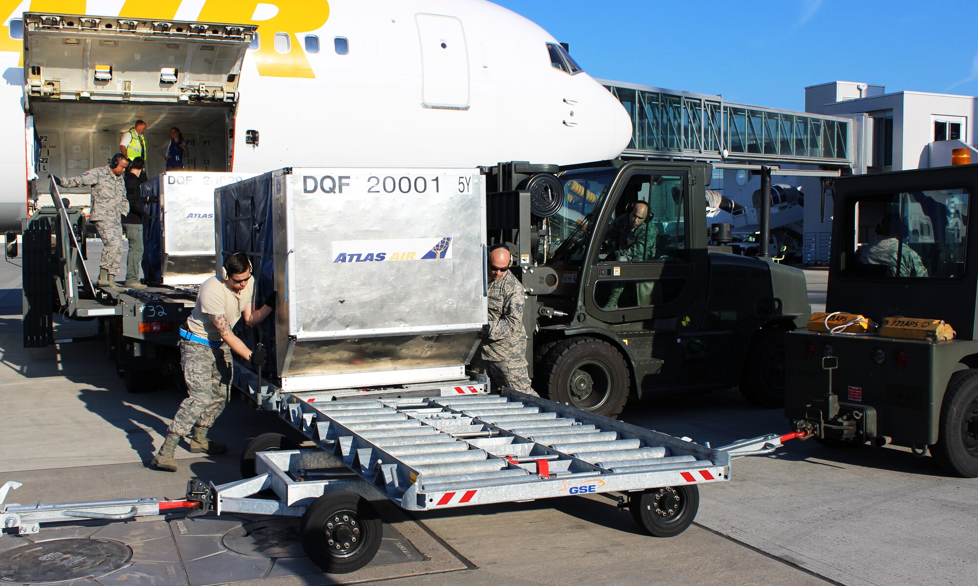 Airmen with the 721st Aerial Port Squadron use a modified dolly, dubbed the “Donnelly Loader,” to off load baggage June 24, 2014, at Ramstein Air Base, Germany. The “Donnelly Loader,” is planned to replace the method of loading and unloading baggage from airframes manually. The system involves moving bins full of baggage down a series of loaders and dollies. (U.S. Air Force photo/ Brennen Lege)