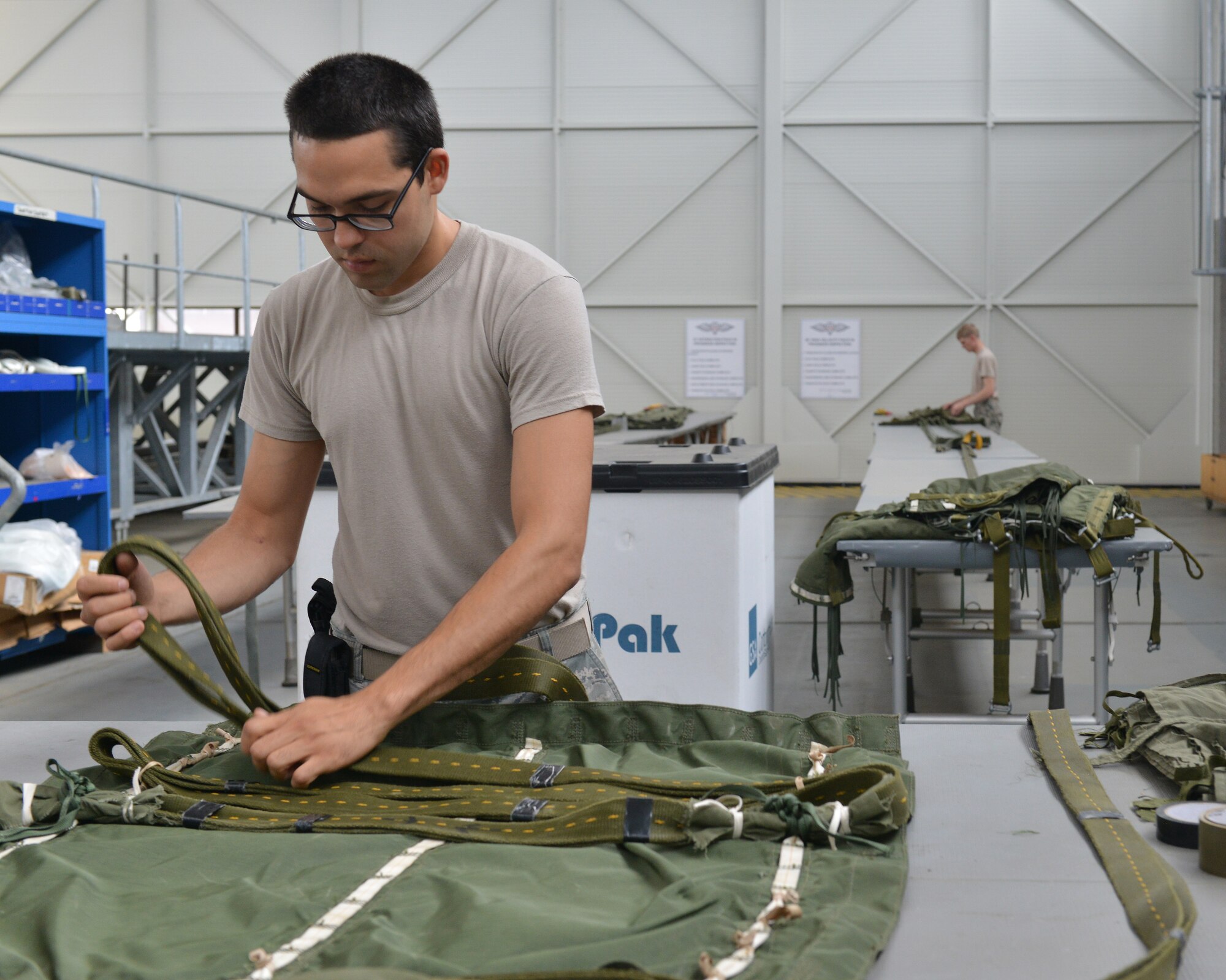 Senior Airman Brian Rodriguez, 86th Logistics Readiness Squadron aerial delivery specialist, prepares half bags July 23, 2014, Ramstein Air Base, Germany. Airmen of the aerial delivery department prepare different types of cargo parachutes and goods for air drops support missions around the world. (U.S. Air Force photo/Senior Airman Holly Mansfield)