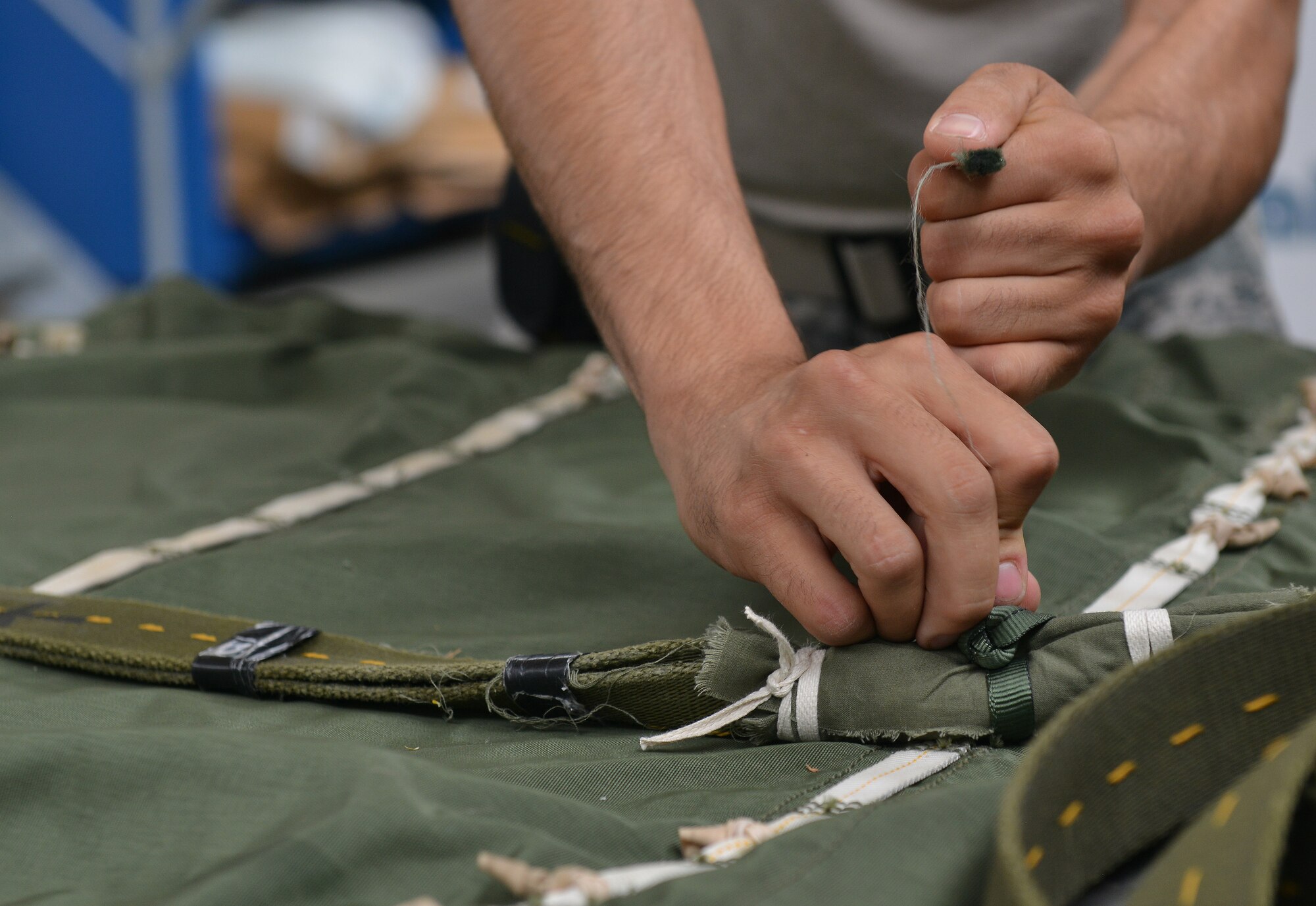 Senior Airman Brian Rodriguez, 86th Logistics Readiness Squadron aerial delivery specialist, prepares half bags July 23, 2014, Ramstein Air Base, Germany. Airmen of the aerial delivery department prepare different types of cargo parachutes and goods for air drops support missions around the world. (U.S. Air Force photo/Senior Airman Holly Mansfield)