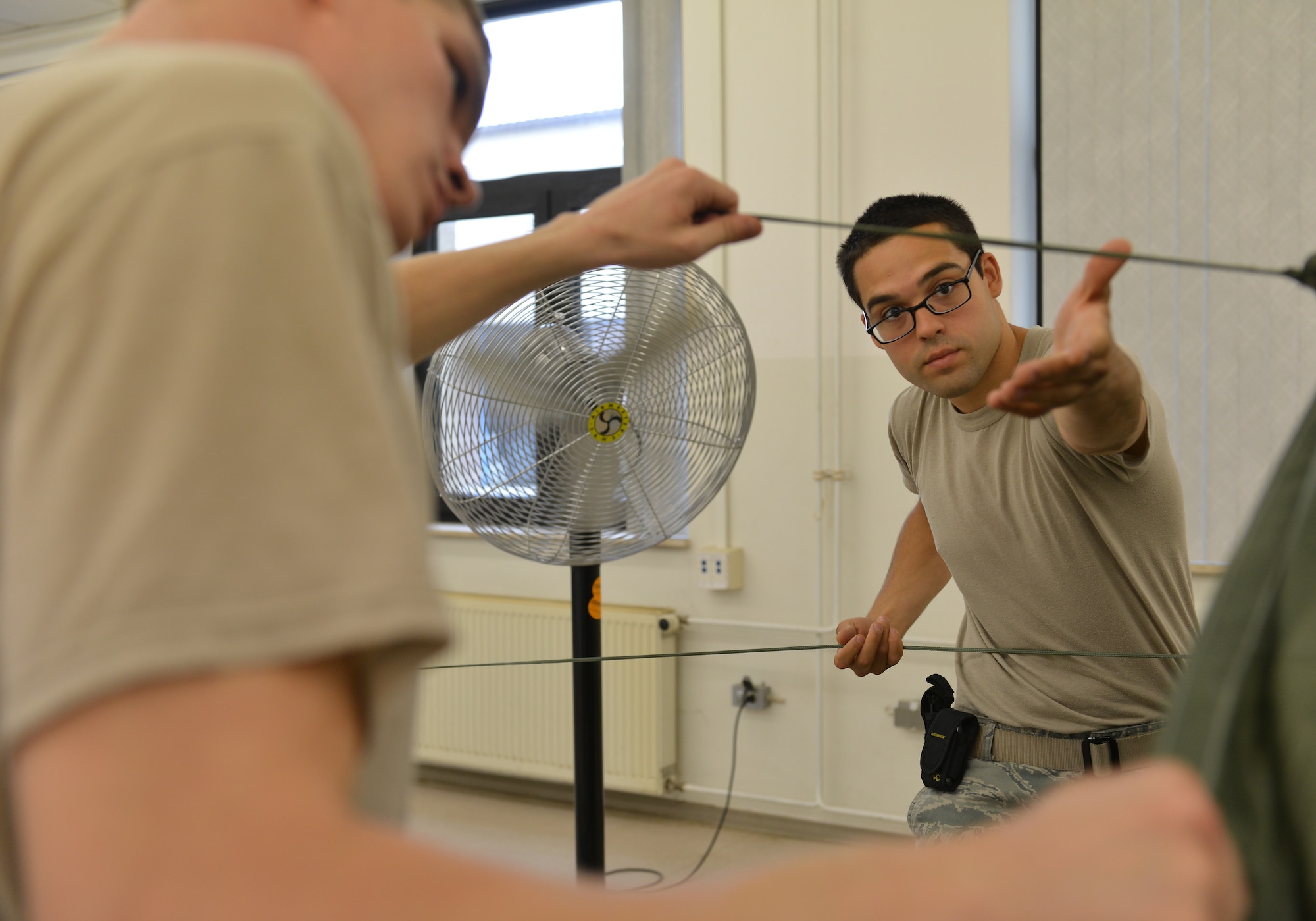 Senior Airman Brian Rodriguez and Airman 1st Class Kyle Taylor, 86th Logistics Readiness Squadron aerial delivery specialists, inspect a cargo parachute before it gets folded, July 23, 2014, Ramstein Air Base, Germany. Airmen of the aerial delivery department prepare different types of cargo parachutes and goods for air drops support missions around the world. (U.S. Air Force photo/Senior Airman Holly Mansfield)