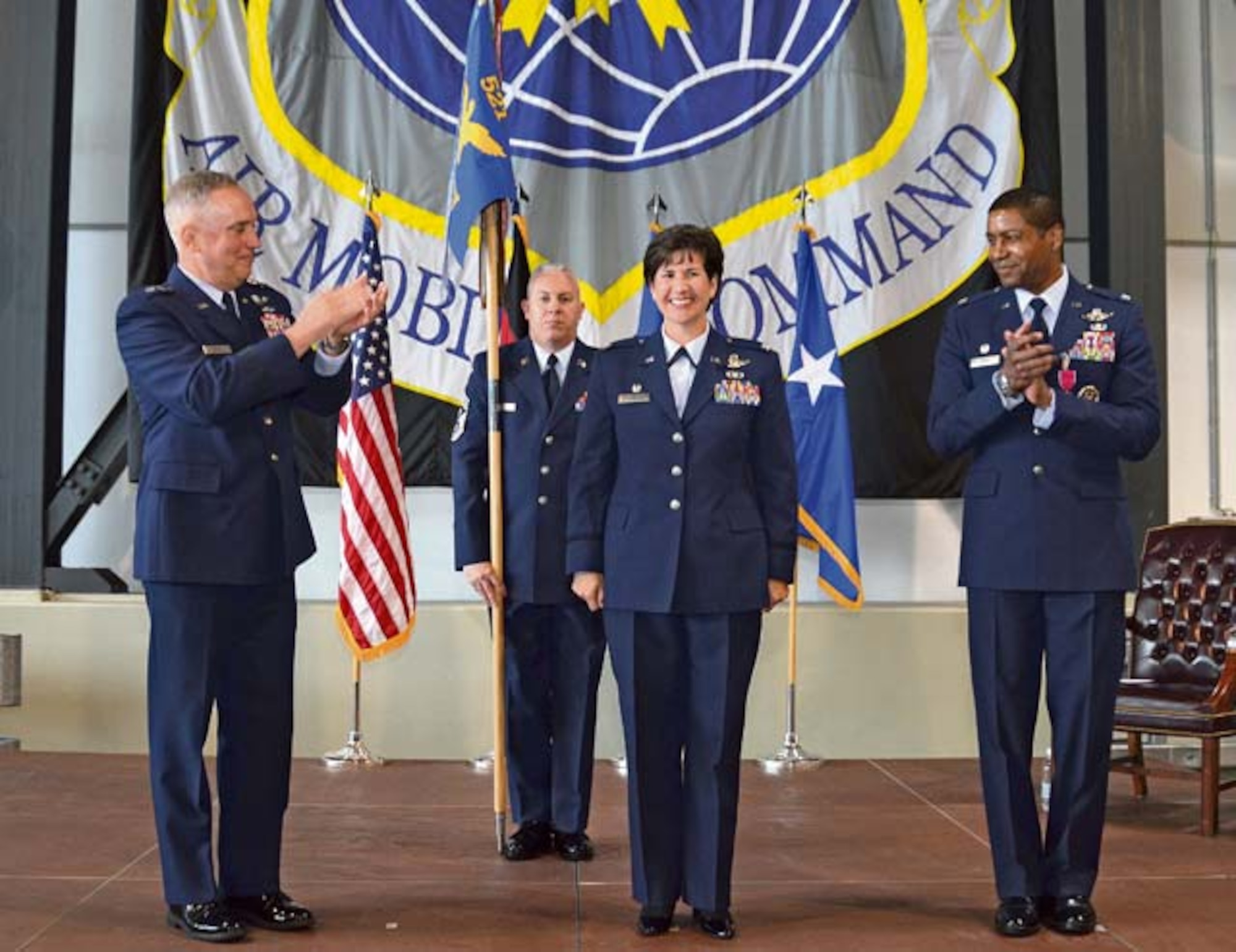 Col. Nancy Bozzer, 521st Air Mobility Operations Wing commander, is recognized by Maj. Gen. Frederick “Rick” Martin (left), U.S. Air Force Expeditionary Center commander, Col. Randall Reed (right) and members of the wing during the 521st AMOW change of command June 18, 2014 on Ramstein, Air Base.
