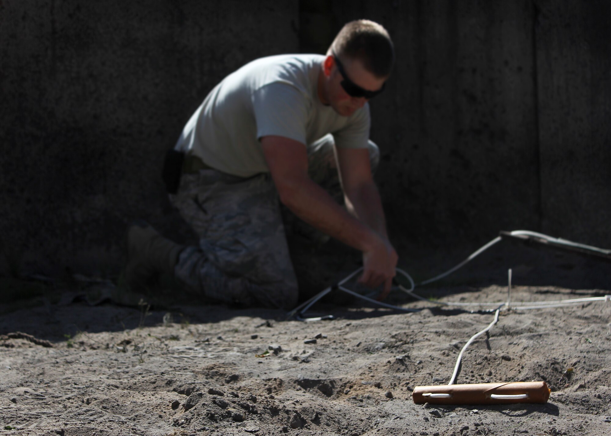 Airman 1st Class Htyler Kelley, 886th Civil Engineer Squadron explosive ordnance disposal technician, places explosives during training June 26, 2014, at Ramstein Air Base, Germany. The Ramstein EOD Airmen provides support to three wings, 26 geographically separated units and two U.S. Army brigades. (U.S. Air Force photo/ Brennen Lege)