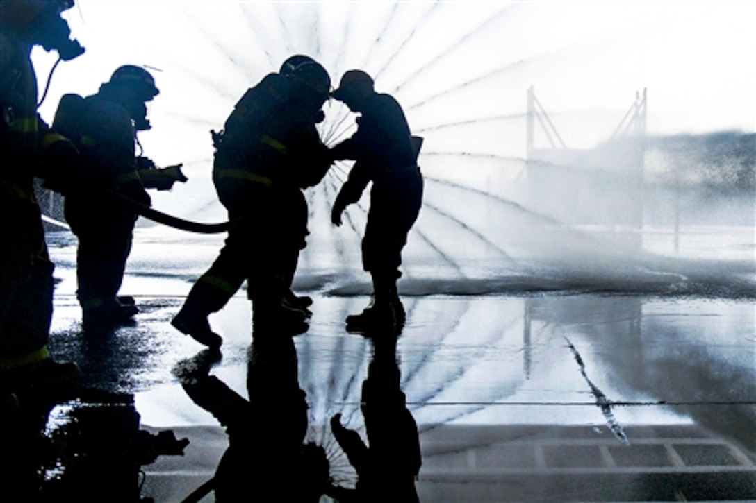 U.S. sailors practice hose handling in the hangar bay of the aircraft carrier USS Harry S. Truman during a general quarters drill in the Atlantic Ocean, July 18, 2014. The drills prepare sailors for the highest state of readiness in the event of actual casualties. 