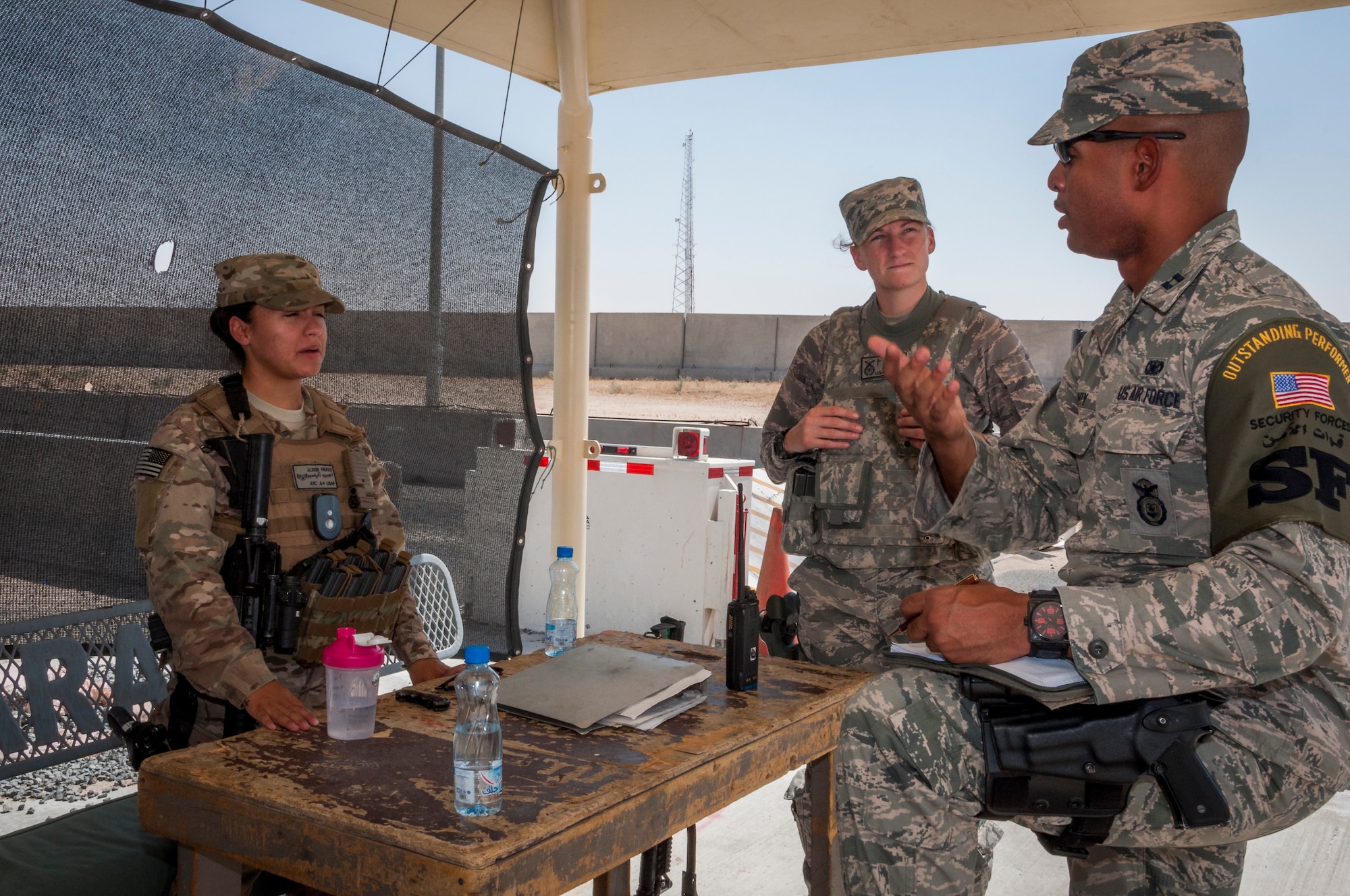 U.S. Air Force Capt. Kenneth Canty, 386th Expeditionary Security Forces, operations officer, deployed from MacDill Air Force Base and a Miami native, conducts a post visit at one of the entry control points at a base in Southwest Asia July 23, 2014. Canty engages with Defenders Senior Airman Alexandra Klus, deployed from the 445th SFS, Wright-Patterson AFB and a native of Cincinatti, Ohio, and Airman 1st Class Alexis Fierro, deployed from the Air Force Academy, Colorado and a native of Houston, Texas. All defenders from the 386th ESFS deployed in support of Operation Enduring Freedom. (U.S. Air Force photo by Senior Master Sgt. Allison Day)