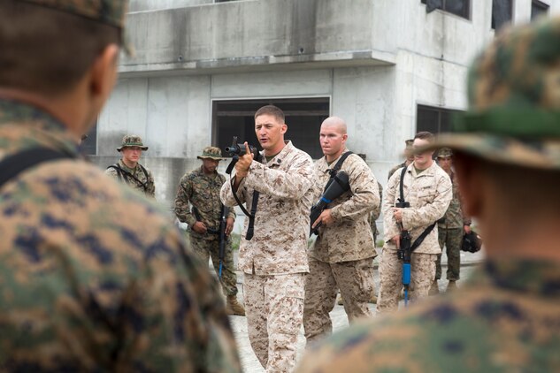 Staff Sgt. Nathan Southwick, a Tactical Readiness and Training instructor with Combat Logistics Regiment 37, demonstrates how to clear a room while doing Military Operations on Urban Terrain training to Combat Logistics Company 36 Marines and augments during Exercise Dragon Fire 2014 at Combined Arms Training Center Camp Fuji, Japan, July 17. Southwick is with an infantrymen group that assists various units within the 3rd Marine Logistics Group. 