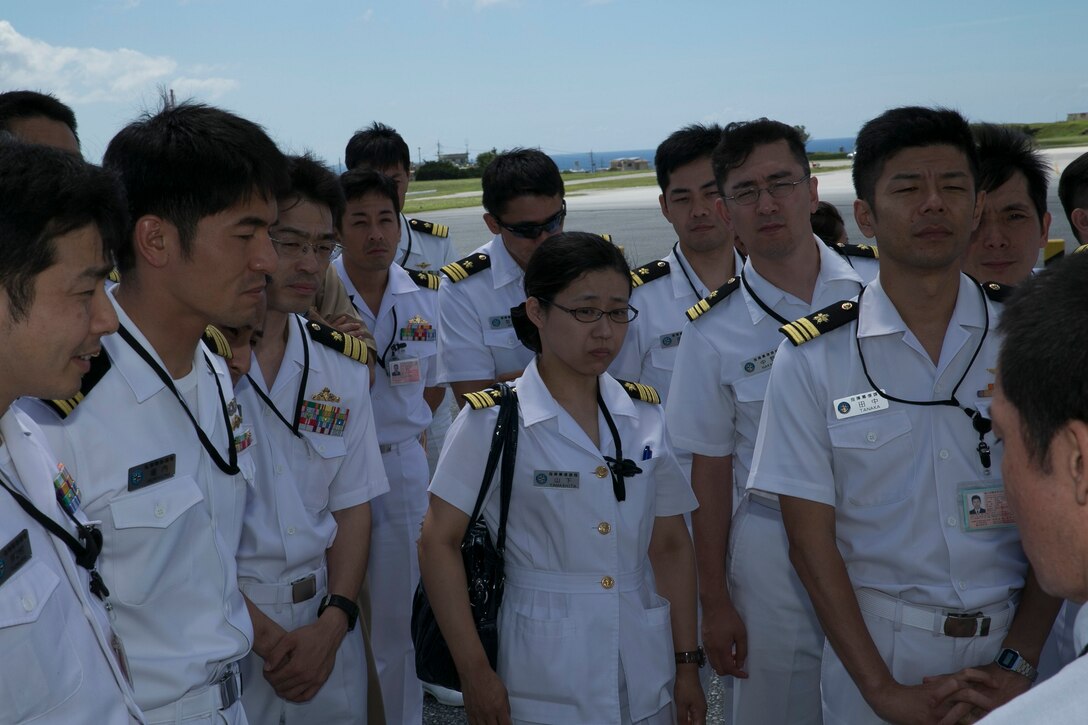 Commissioned officers and senior enlisted service members with the Japan Maritime Self-Defense Force Command and Staff College listen intently to Marine Capt. Robin D. Brewer, July 16, at Marine Corps Air Station Futenma, Okinawa. The Okinawan sailors participated in an extensive question-and-answer-style briefing, followed by a static display of an MV 22B Osprey tiltrotor aircraft. Before going up to the aircraft, Brewer questions the JMSDF attendees had regarding the Osprey and its capabilities. Brewer is a Tallahassee, Florida, native and an Osprey pilot with Marine Medium Tiltrotor Squadron 265, Marine Aircraft Group 36, 1st Marine Aircraft Wing, III Marine Expeditionary Force. (U.S. Marine Corps photo by Lance Cpl. Pete Sanders/Released)