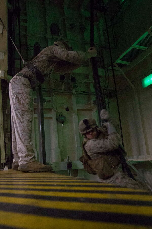 U.S. 5TH FLEET AREA OF RESPONSIBILITY (July 19, 2014) A U.S. Marine with Battalion Landing Team 1st Battalion, 6th Marine Regiment, 22nd Marine Expeditionary Unit (MEU), fast ropes down an elevator shaft during a low-light fast rope exercise aboard the amphibious transport dock ship USS Mesa Verde (LPD 19). The 22nd MEU is deployed with the Bataan Amphibious Ready Group as a theater reserve and crisis response force throughout U.S. Central Command and the U.S. 5th Fleet area of responsibility. (U.S. Marine Corps photo by Cpl. Manuel A. Estrada/Released)