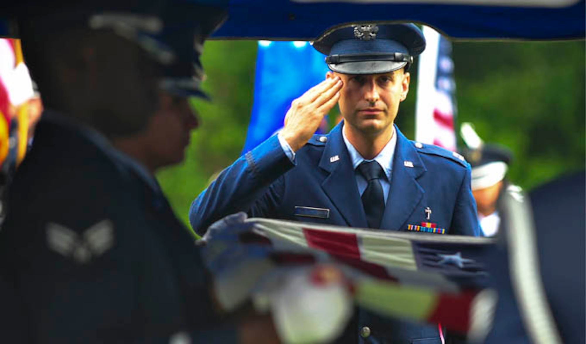 Chaplain (Capt.) Matthew Dussia salutes the remains of Capt. Robert Turnbull Sr., July 19, 2014 at Barnetts Creek Baptist Church Cemetery, Ga. Thomas County, Ga. Trunbull was one of 52 service members lost during a C-124 Globemaster crash in Alaska in 1952. Dussia is  a chaplain with the 325th Fighter Wing. (U.S. Air Force photo/Airman 1st Class Dustin Mullen)