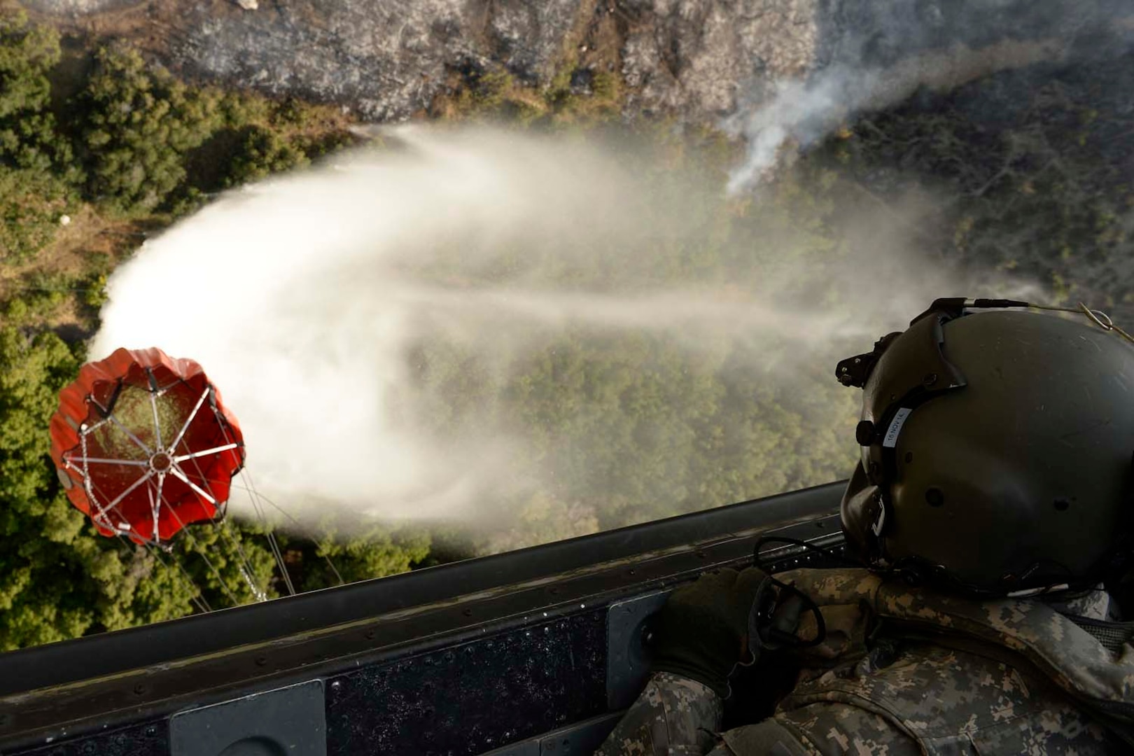 Utah Army National Guard Staff Sgt. Jason Towensend, 2-211 Aviation Battalion, drops water on the Tunnel Hallow fire near Morgan, Utah, July 23, 2014. The two HH-60 Black Hawks assisting with the fire were able to drop more than 29,000 gallons of water on the fire. 
