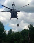 A New York Army National Guard flight medic from the Rochester, N.Y.-based Company F, 1st Battalion, 169th Aviation (Air Ambulance), rises up from the wood line to conduct medical evacuation training with infantry Soldiers from the New York Army National Guard's 2nd Platoon, Company C, 2nd Battalion, 108th Infantry, from Gloversville, N.Y. The two units trained jointly during their New York Army National Guard Annual Training, July 17, 2014.