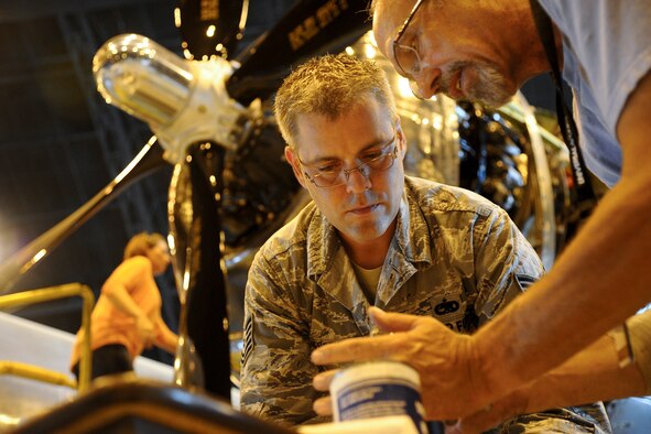 Tech. Sgt. Geoffrey Jensen places a cap on a fuel booster pump of a Boeing B-29 Superfortress, July 22, 2014, in Wichita, Kansas. Jensen along with many other volunteers are restoring the B-29 to flying condition. Jensen is the 22nd Maintenance Group logistic resource management program NCO in charge. (U.S. Air Force photo/Airman 1st Class John Linzmeier)