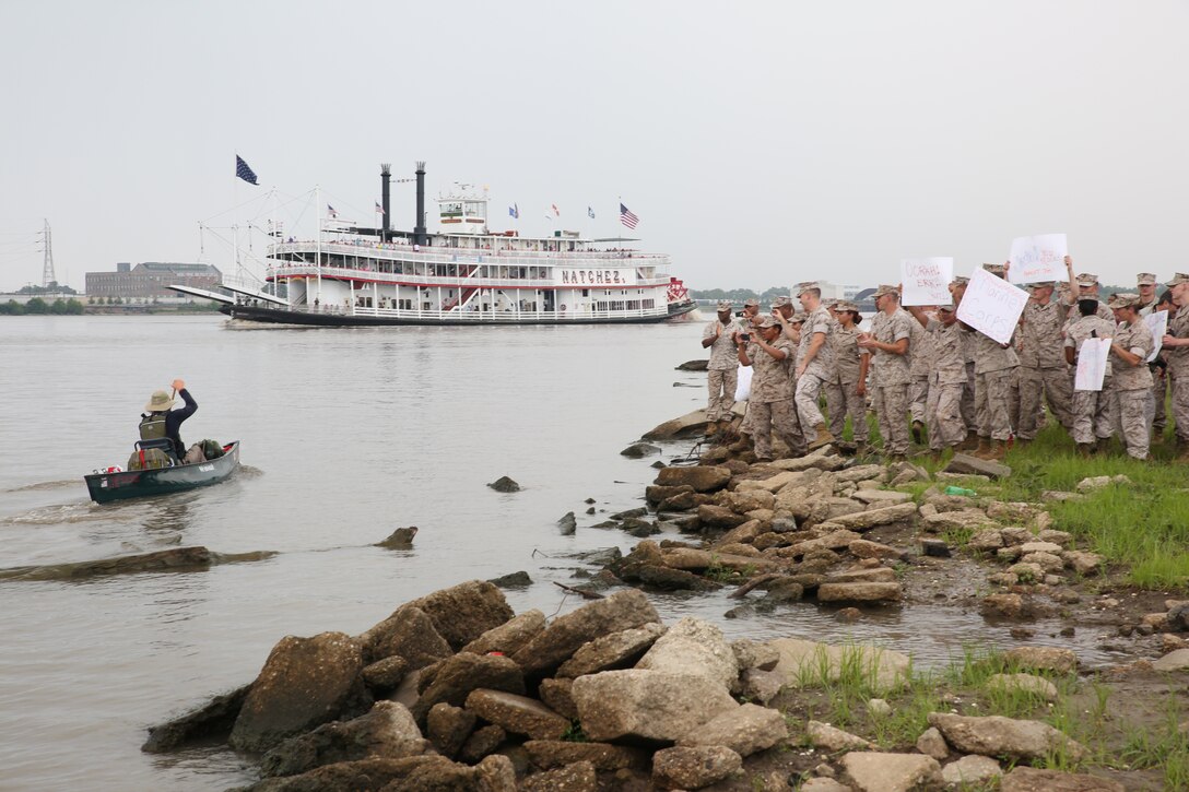 Marines and sailors from Headquarters, Marine Forces Reserve greet former Marine Cpl. Joshua Ploetz, as he paddles closer to the end of his 2,575-mile journey down the Mississippi River, in New Orleans, July 25, 2014. Ploetz began his journey to raise awareness for post-traumatic stress May 19, at Lake Itasca Minn. 