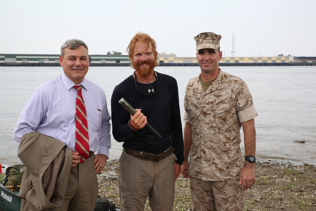 Gregg T. Habel, executive director Marine Forces Reserve and Marine Forces North (left), former active-duty Marine Cpl. Joshua Ploetz, a combat veteran (middle) and Lt. Col. Steven Godinho, Marine Forces Reserve Headquarters Battalion commanding officer (right) stand together July 25, 2014 after Ploetz comes ashore at Algiers Point along the Mississippi River. Ploetz paddled nearly 2,575-miles down the Mississippi to raise awareness for post-traumatic stress.  