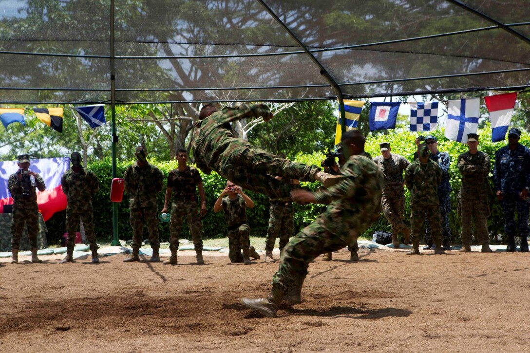 Colombian Marines demonstrate martial arts techniques for Marines and Sailors with Special Purpose Marine Air Ground Task Force South during a martial arts training exchange at Colombian Marine Corps Base Coveñas, Colombia, July 16, 2014. The SPMAGTF came to Colombia aboard the future amphibious assault ship USS America (LHA 6) during its transit around South America. A SPMAGTF is a balanced air, ground and logistics force that can be tailored to accomplish missions across a wide range of crises. As the first stop on the ship's transit, the visit to Colombia also represents the first time Marines and Sailors have been tactically inserted into an environment from the newly built ship. Through partner-nation activities, key leader engagements and security cooperation activities, the visit aims at further strengthening our partnership in the region, increasing interoperability and building mutual trust between the U.S. and Colombia. (U.S. Marine Corps photo by Cpl. Christopher J. Moore/Released)