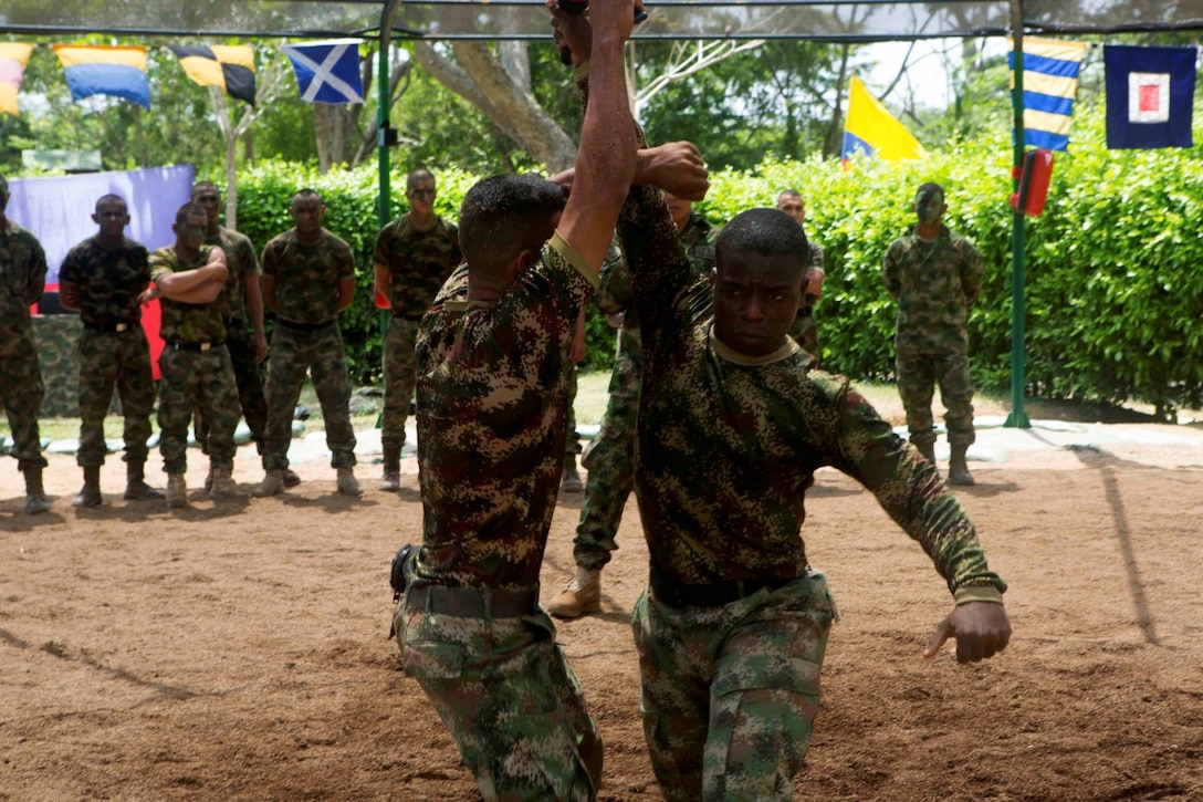 Colombian Marines demonstrate martial arts techniques for Marines and Sailors with Special Purpose Marine Air Ground Task Force South during a martial arts training exchange at Colombian Marine Corps Base Coveñas, Colombia, July 16, 2014. The SPMAGTF came to Colombia aboard the future amphibious assault ship USS America (LHA 6) during its transit around South America. A SPMAGTF is a balanced air, ground and logistics force that can be tailored to accomplish missions across a wide range of crises. As the first stop on the ship's transit, the visit to Colombia also represents the first time Marines and Sailors have been tactically inserted into an environment from the newly built ship. Through partner-nation activities, key leader engagements and security cooperation activities, the visit aims at further strengthening our partnership in the region, increasing interoperability and building mutual trust between the U.S. and Colombia. (U.S. Marine Corps photo by Cpl. Christopher J. Moore/Released)