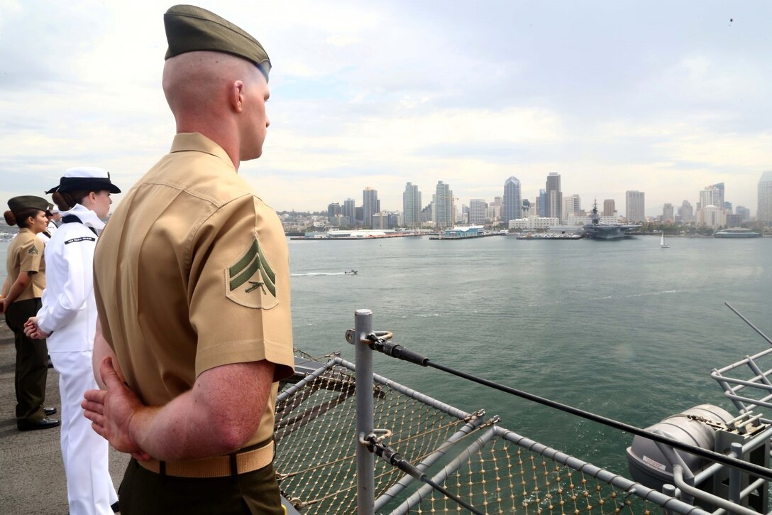 Cpl. Michael J. Rice, a Cyber Network Specialist and Bridgewater, New Jersey native with the 11th Marine Expeditionary Unit, mans the rails while the USS Makin Island departs San Diego, July 25, 2014. While on a naval vessel, Marines and sailors will dress in their designated service uniform and stand evenly spaced along the rails of the ship while it is entering or leaving port. (U.S. Marine Corps photo by Lance Cpl. Laura Y. Raga/Released)