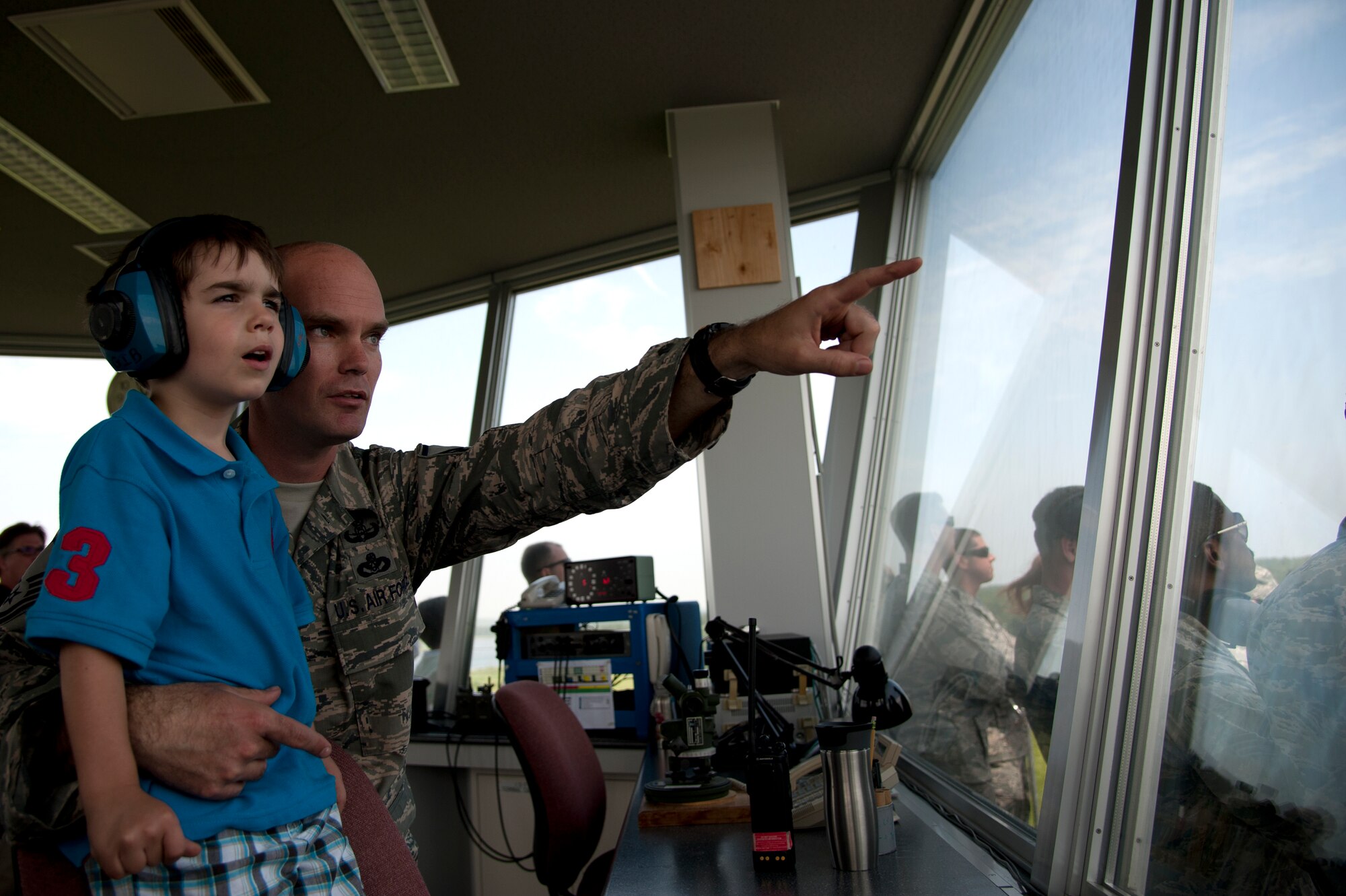 U.S. Air Force Master Sgt. Cary Gibson, 35th Civil Engineer Squadron explosive ordnance disposal flight chief, points out an F-16 Fighting Falcon at Draughon Range to his son, Japan, July 18, 2014. Pilots hone their bombing skills with BDU-33s, 25-pound concrete-filled bombs that release a cloud of smoke on impact. 35 CES EOD members like Gibson help clear the range of ordnance after training is completed. (U.S. Air Force photo/ Staff Sgt. Tong Duong)