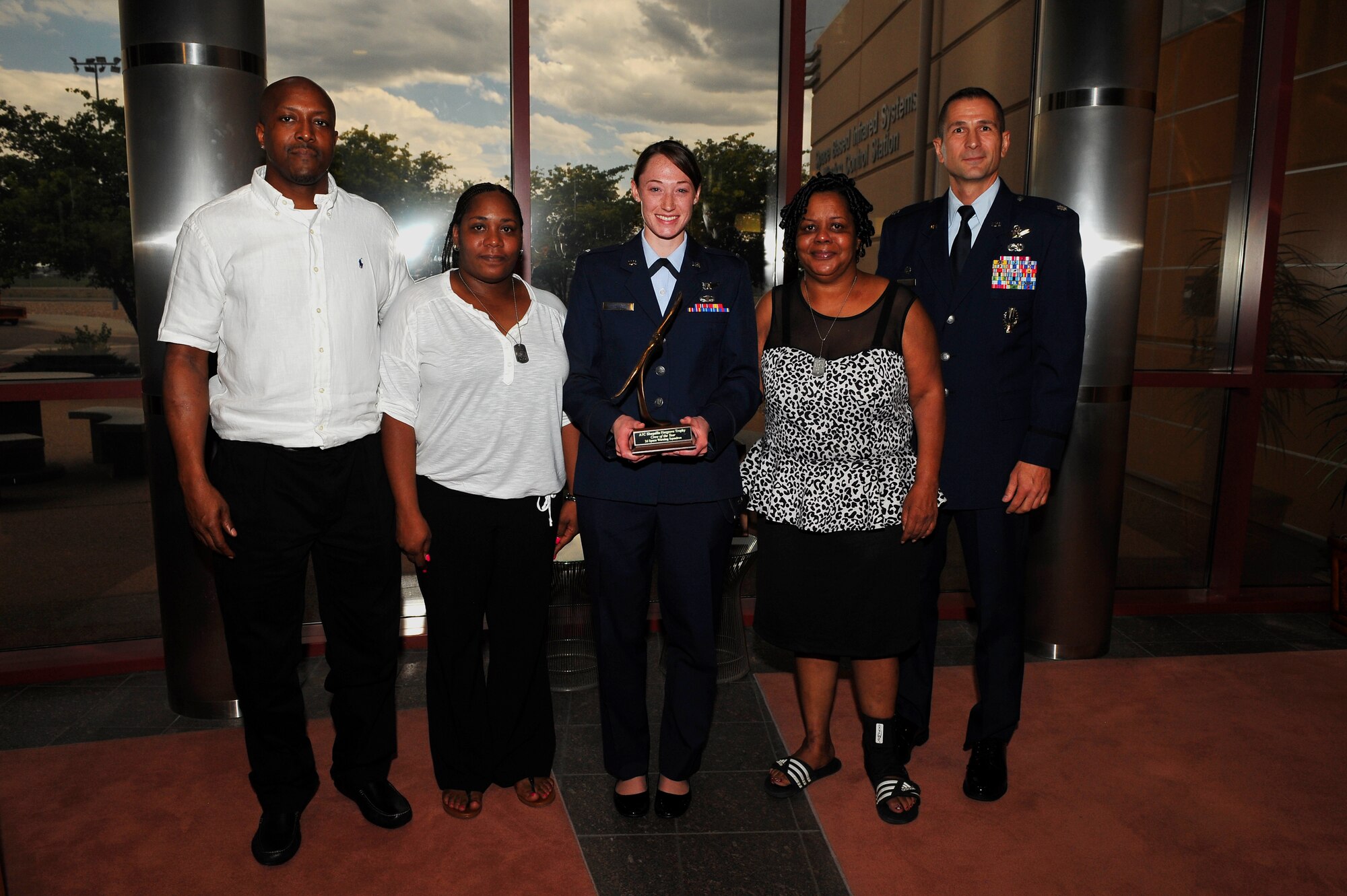1st Lt. Laura Henderson, 2nd Space Warning Squadron Delta Crew commander, center, received the A1C Shaquille Hargrove Crew of the Year award from Hargrove’s parents, left, and grandmother, second from right, July 25, 2014, at the 460th Operations Group Mission Control Station on Buckley Air Force Base, Colo. This award was created to honor Hargrove, who was killed in an incident July 2013 in downtown Denver. The award is presented to the crew that demonstrates the highest level of excellence within the squadron. (U.S. Air Force photo by Senior Airman Phillip Houk/Released)