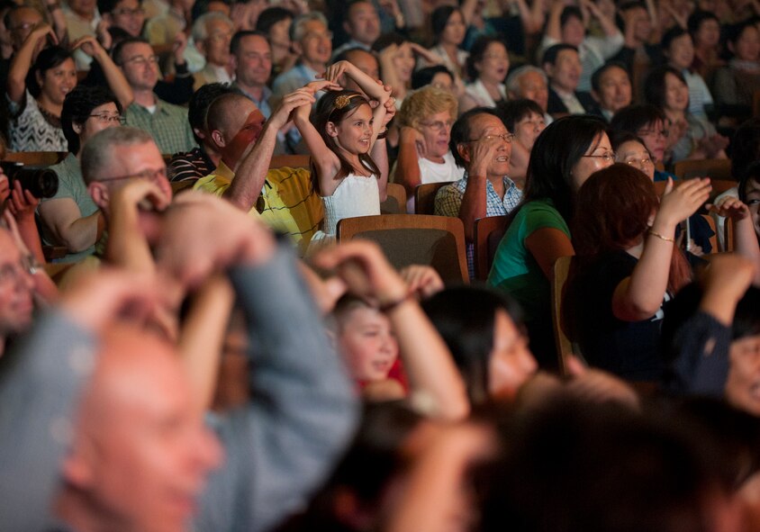 Audience members from Misawa Air Base and the local community follow along with TOPS IN BLUE performers at the Misawa Civic Center in Misawa, Japan July 25, 2014. Members of the United States Air Force’s entertainment group performed 90 minutes of non-stop live entertainment for attendees. (U.S. Air Force photo/ Staff Sgt. Tong Duong)