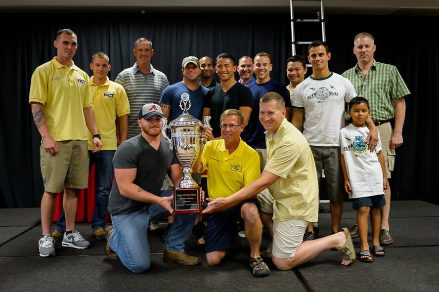 U.S. Air Force Retired Col. Todd McCready, center, former 7th Maintenance Group commander, stands with Dyess Airmen assigned to the 7th Civil Engineer Squadron (CES) July 26, 2014, at the 14th Annual Dyess We Care Team Awards Banquet at McMurry University in Abilene, Texas. The 7th CES was awarded the Volunteer Squadron of the Year Award for the second year in a row. (Courtesy photo)