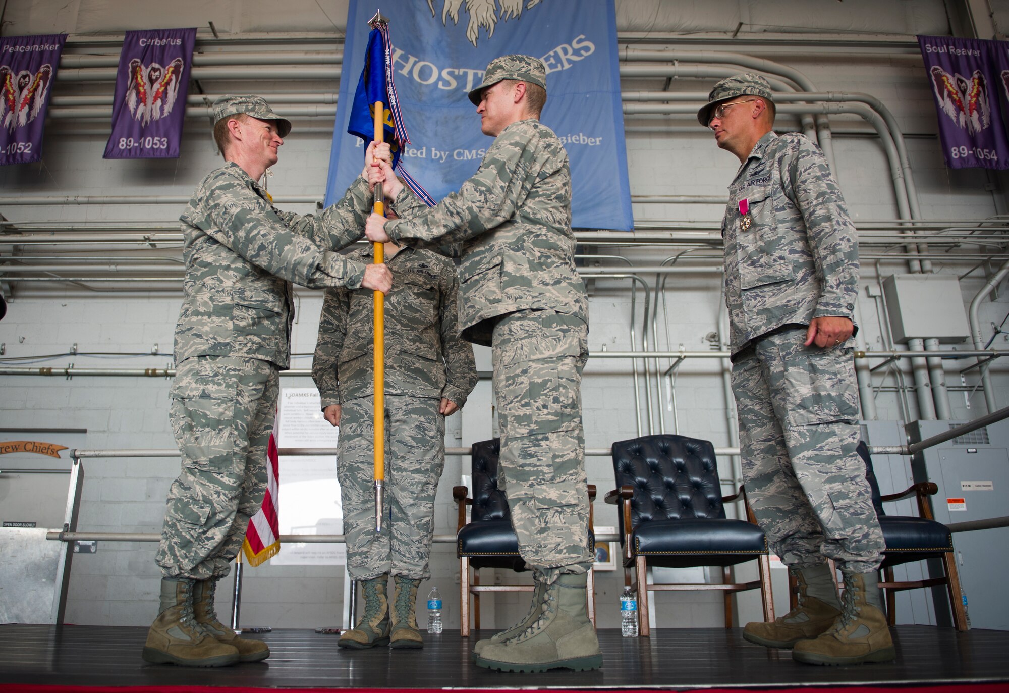 Col. Bill West, 1st Special Operations Wing commander, hands the 1st Special Operations Mission Support Group guidon to Col. Todd Fogle during a change of command ceremony at the Commando Hangar on Hurlburt Field, Fla., July 28, 2014. Fogle assumed command of the 1st SOMSG accompanied by his wife Johanna and three children. (U.S. Air Force photo/Senior Airman Christopher Callaway) 