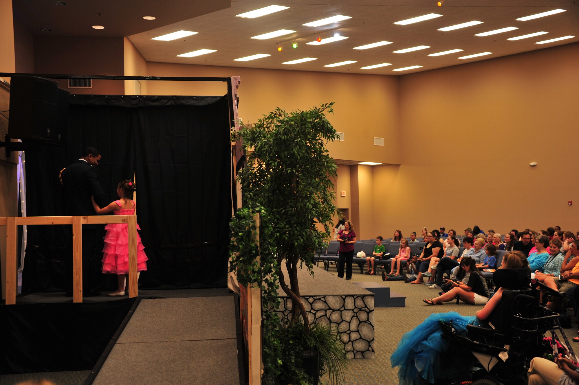 U.S. Air Force ROTC cadet Damarius Pettway, military volunteer, talks to a pageant participant before escorting her to the stage at the Alabama Angels Pageant July 26, 2014. The pageant recognizes specials needs participants of all ages and gender. Pettway volunteered for the event along with approximately two dozen members from Maxwell Air Force Base. (U.S. Air Force photo by Staff Sgt. Natasha Stannard)