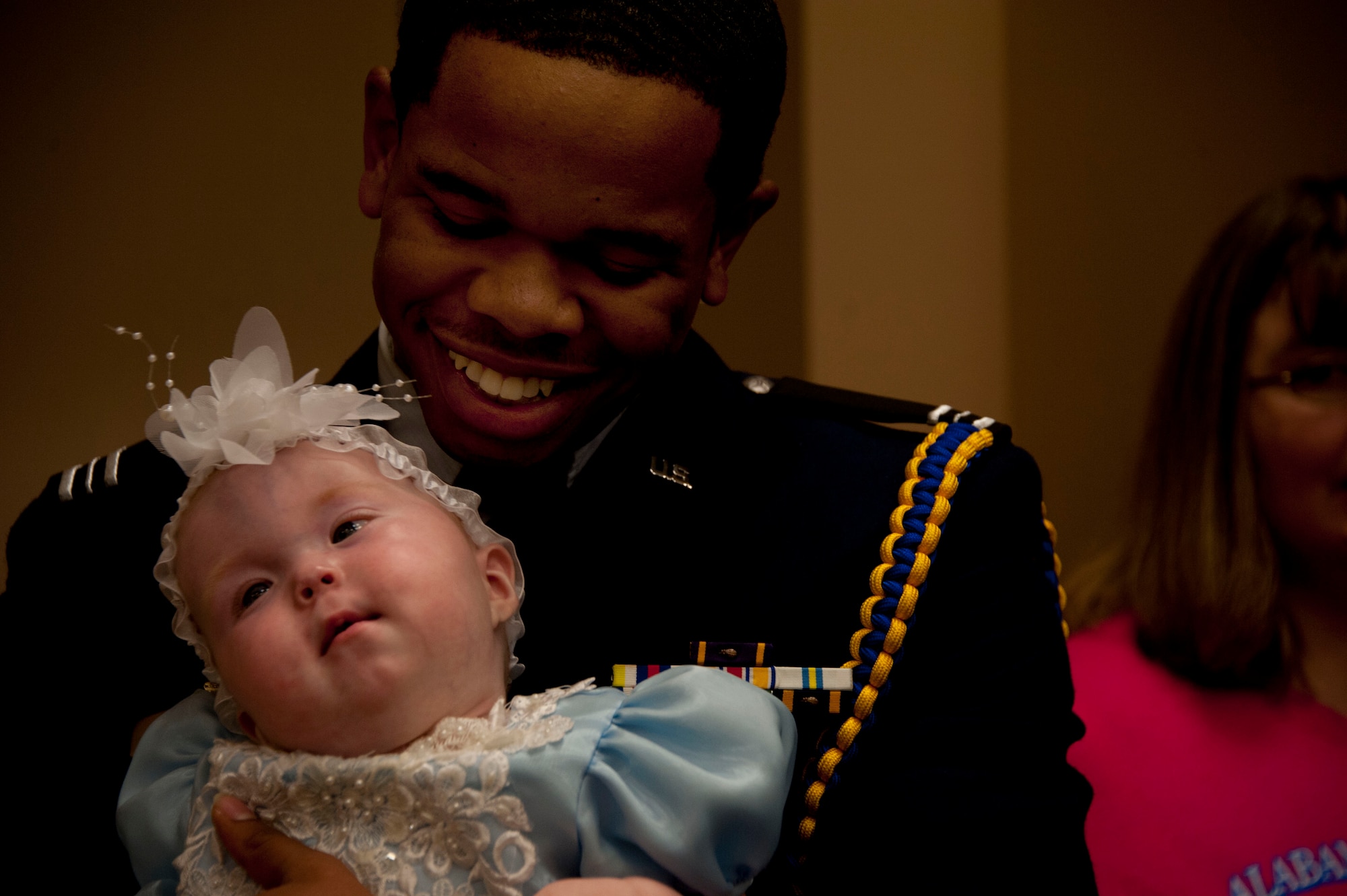 U.S. Air Force ROTC cadet Damarius Pettway, military volunteer, holds a pageant participant in his arms at the Alabama Angels Pageant July 26, 2014. The pageant recognizes specials needs participants of all ages and gender. Pettway volunteered for the event along with approximately two dozen members from Maxwell Air Force Base. (U.S. Air Force photo by Staff Sgt. Natasha Stannard)