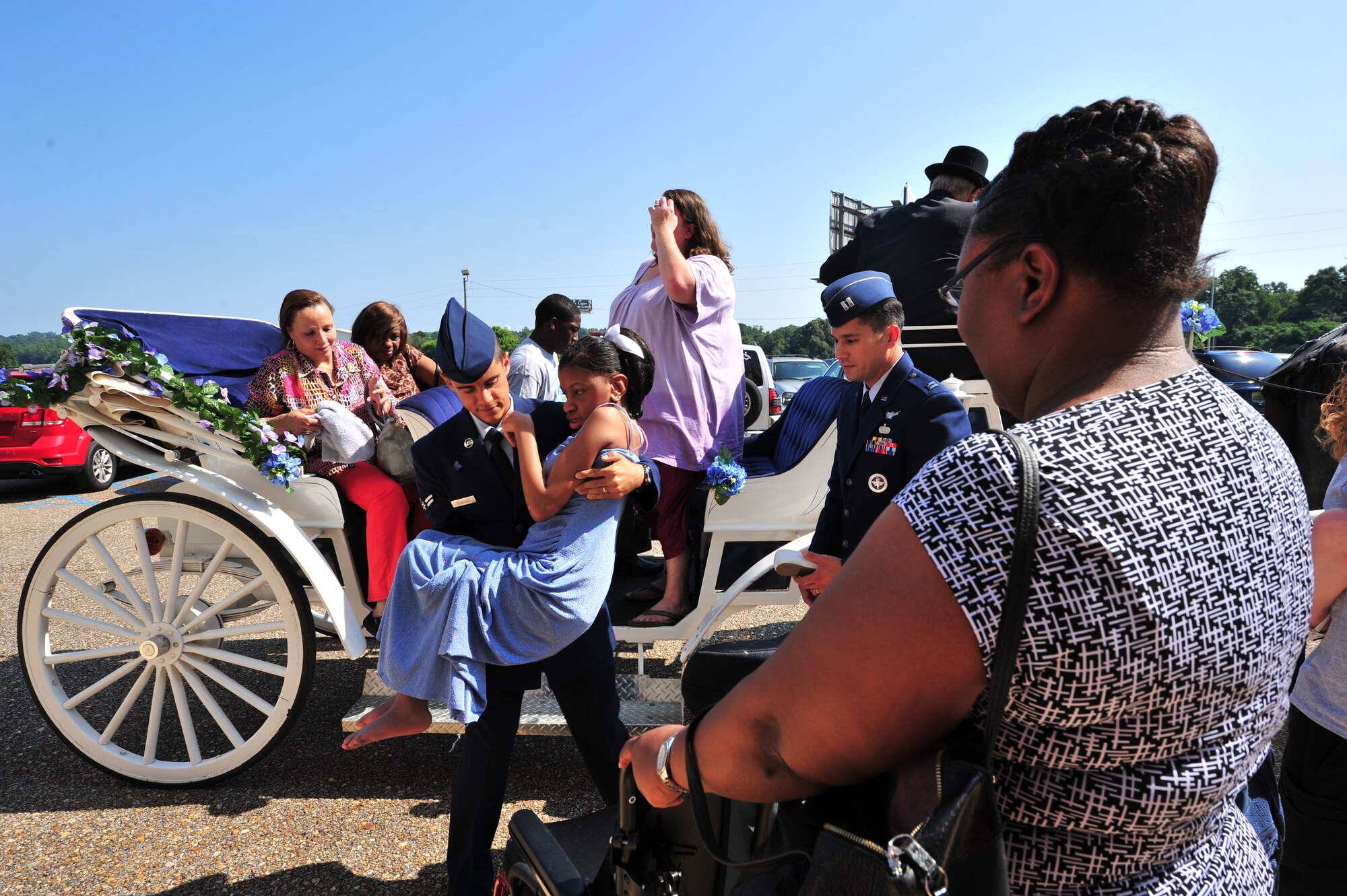 Airman 1st Class Chris Elszasz, a military volunteer from Maxwell Air Force Base, helps a pageant participant into her wheel chair at the Alabama Angels Pageant July 26, 2014. The pageant recognizes specials needs participants of all ages and gender. Military volunteers from Maxwell helped set-up and facilitate the event. (U.S. Air Force photo by Staff Sgt. Natasha Stannard)