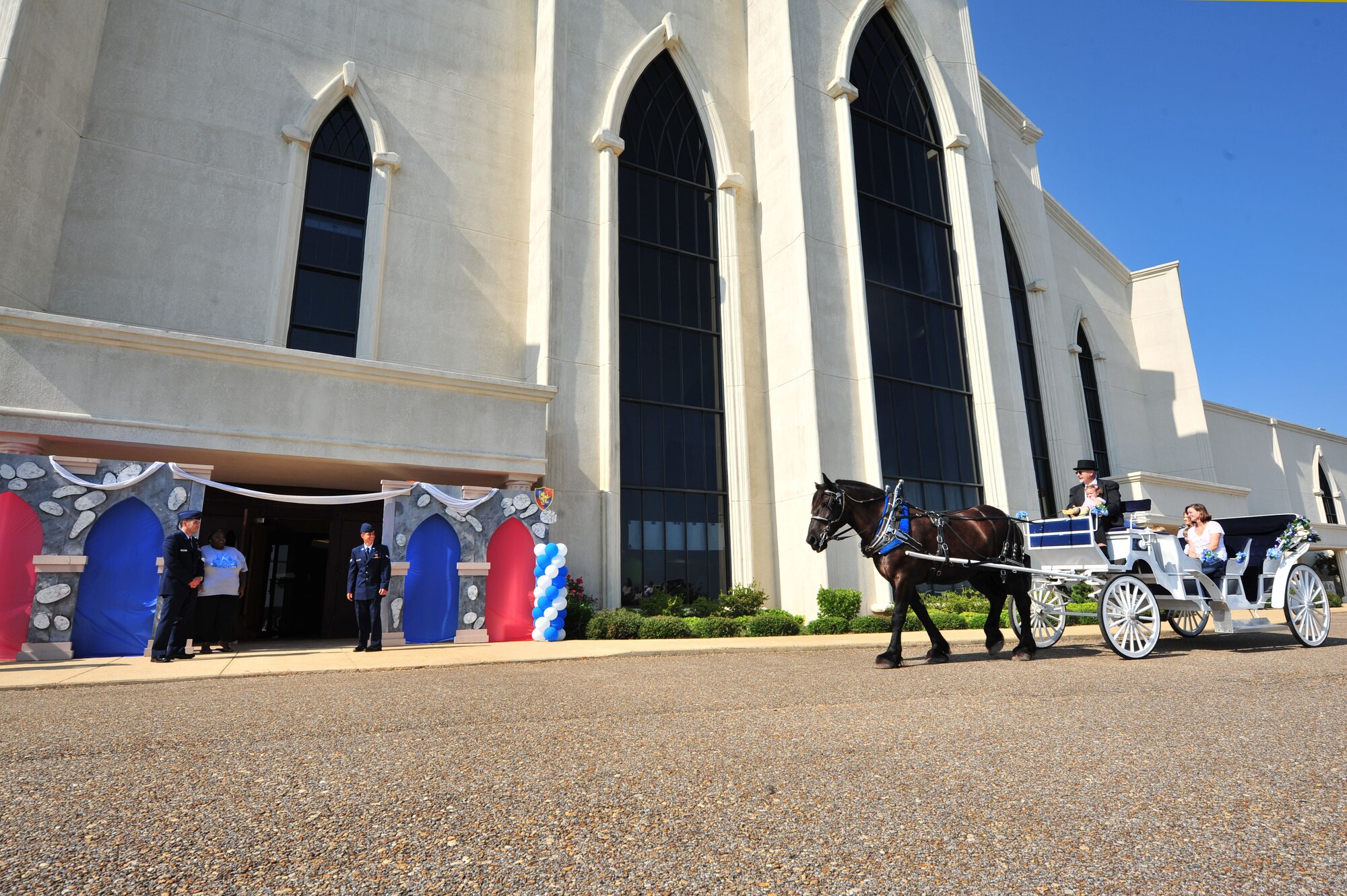 Capt. Michael Davault, left, and Airman 1st Class Chris Elszasz, military volunteers from Maxwell Air Force Base, to help  pageant participants off a carriage ride at the Alabama Angels Pageant July 26, 2014. Davault and Elszasz volunteered with approximately two-dozen other Maxwell volunteers for the special needs pageant. (U.S. Air Force photo by Staff Sgt. Natasha Stannard)