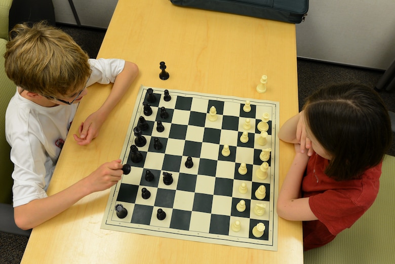 Caleb Hammon, 11-year-old son of U.S Air Force Lt. Col. Troy Hammon, U.S. Air Forces Central chief of contract and fiscal law, and Victoria Hobbs, 9-year-old daughter of Staff Sgt. Sharla Hobbs, 31st Intelligence Squadron, Detachment 1, senior tactics analyst, play chess at Shaw Air Force Base, S.C., July 22, 2014. The chess club has a total of 18 participants who take turns using the chess boards to hone their chess skills. (U.S. Air Force photo by Airman 1st Class Diana M. Cossaboom/Released)