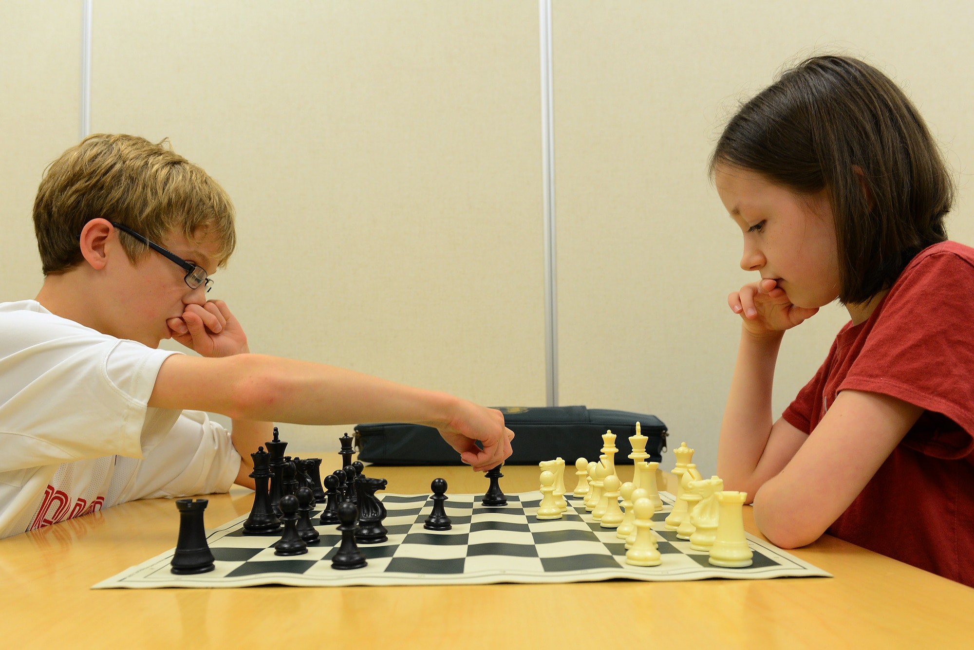 Caleb Hammon, 11-year-old son of U.S Air Force Lt. Col. Troy Hammon, U.S. Air Forces Central chief of contract and fiscal law, and Victoria Hobbs, 9-year-old daughter of Staff Sgt. Sharla Hobbs, 31st Intelligence Squadron, Detachment 1, senior tactics analyst, play chess at Shaw Air Force Base, S.C., July 22, 2014. The chess club is open to everyone, especially children ages 6 to 12. (U.S. Air Force photo by Airman 1st Class Diana M. Cossaboom/Released)