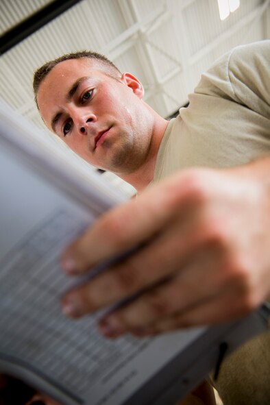 U.S. Air Force Staff Sgt. Christopher Tarbart, 74th Aircraft Maintenance Unit load crew member, reads through a checklist during a weapons load competition July 25, 2014, at Moody Air Force Base, Ga. Tarbart is a Baltimore, Md., native who served as his team’s chief or one-man. His primary job was to review checklist procedures, empower his teammates and ensure the overall load went smoothly. (U.S. Air Force photo by Staff Sgt. Jamal D. Sutter/Released)