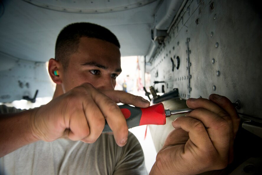 U.S. Air Force Airman 1st Class Xavier Guare, 74th Aircraft Maintenance Unit load crew member, secures a GBU-38 joint direct attack munition to an A-10C Thunderbolt II during a weapons load competition July 25, 2014, at Moody Air Force Base, Ga. Guare and his team raced against a team from the 75th Aircraft Maintenance Unit and, ultimately, won the competition after judges and evaluators tallied their scores. (U.S. Air Force photo by Staff Sgt. Jamal D. Sutter/Released)