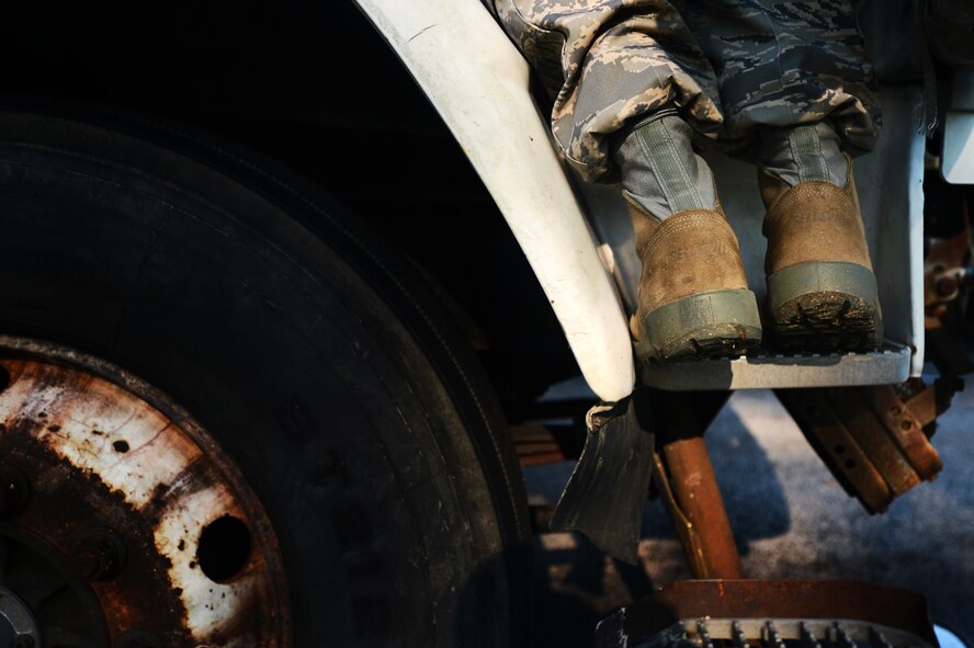 A 20th Security Forces Squadron installation entry control Airman stands on the step of a semi-truck at the commercial vehicle inspection area at Shaw Air Force Base, S.C., July 24, 2014. To ensure base safety, the 20th SFS Airmen check vehicle cabins for drugs, alcohol, explosives and weapons. (U.S. Air Force photo by Airman 1st Class Jensen Stidham/Released) 