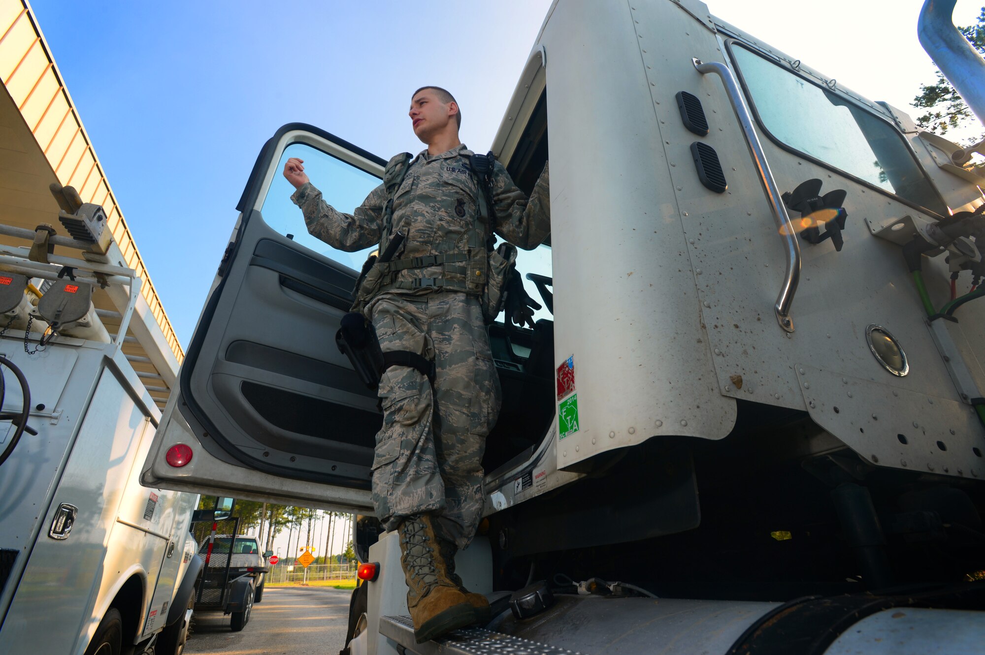 U.S. Air Force Senior Airman Ilya Makarenko, 20th Security Forces Squadron installation entry control journeyman, calls for an Airman at the commercial vehicle inspection area at Shaw Air Force Base, S.C., July 24, 2014. Makarenko found items that needed approval before the driver could be granted access to the installation. (U.S. Air Force photo by Airman 1st Class Jensen Stidham/Released)