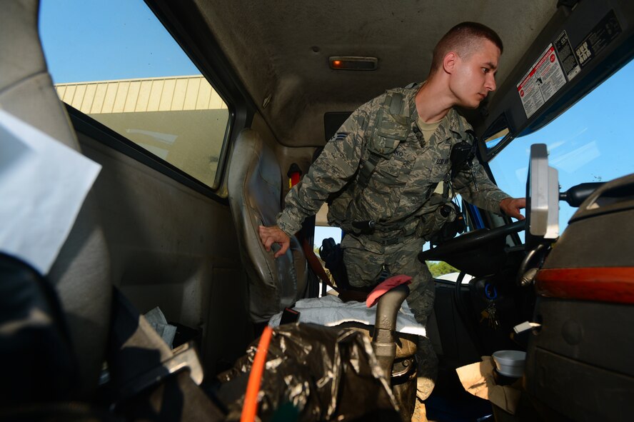 U.S. Air Force Senior Airman Ilya Makarenko, 20th Security Forces Squadron installation entry control journeyman, inspects the inside of a semi-truck at the commercial vehicle inspection area at Shaw Air Force Base, S.C., July 24, 2014. 20th SFS Airmen search through glove compartments, center consoles and underneath seats ensuring no drugs, alcohol, explosives or weapons enter the installation. (U.S. Air Force photo by Airman 1st Class Jensen Stidham/Released)