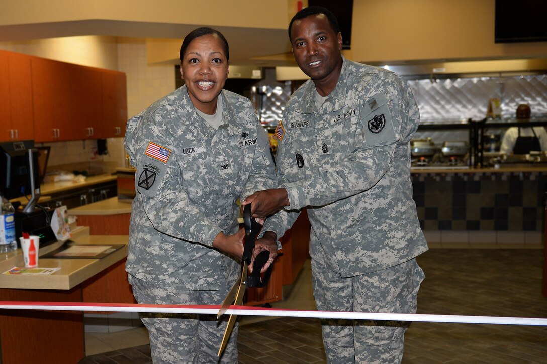 U.S. Army Col. Glenda Lock, McDonald Army Health Center commander, and Command Sgt. Maj. Jessie Sharpe, 733rd Mission Support Group command sergeant major, cut the ceremonial ribbon during the grand re-opening of the MCAHC Dining Facility at Fort Eustis, Va., July 28, 2014. The dining facility re-opened to serve breakfast from 7 a.m. to 10 a.m. and lunch from 11 a.m. to 1:30 p.m. (U.S. Air Force photo by Senior Airman Teresa J.C. Aber/Released)