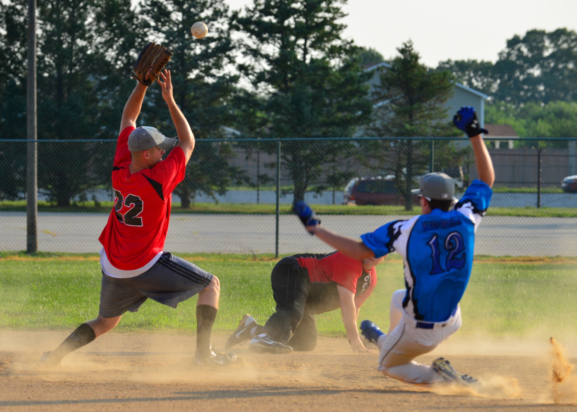 Matthew Kidwell, 436th Maintenance Squadron right fielder, slides into second base during an intramural softball game July 23, 2014, at the field on Dover Air Force Base, Del. Robert Barnes, 436th Civil Engineer Squadron second baseman, was unable to grab the high toss from Michael Jobin, 436th CES shortstop, and Kidwell was called safe on the play. (U.S. Air Force photo/Airman 1st Class William Johnson)