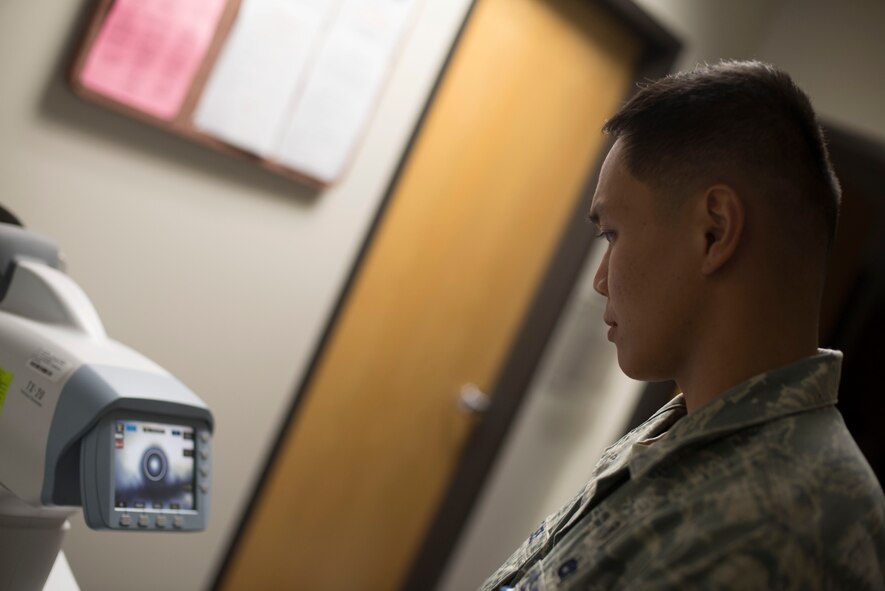 U.S. Air Force Staff Sgt. Francis Angeles, 23d Medical Group medical technician, checks the results of a lensometer test at the optometry clinic at Moody Air Force Base, Ga., July 28, 2014. A lensometer uses existing glasses to evaluate a lens prescription for the patient. (U.S. Air Force photo by Airman 1st Class  Dillian Bamman /Released)