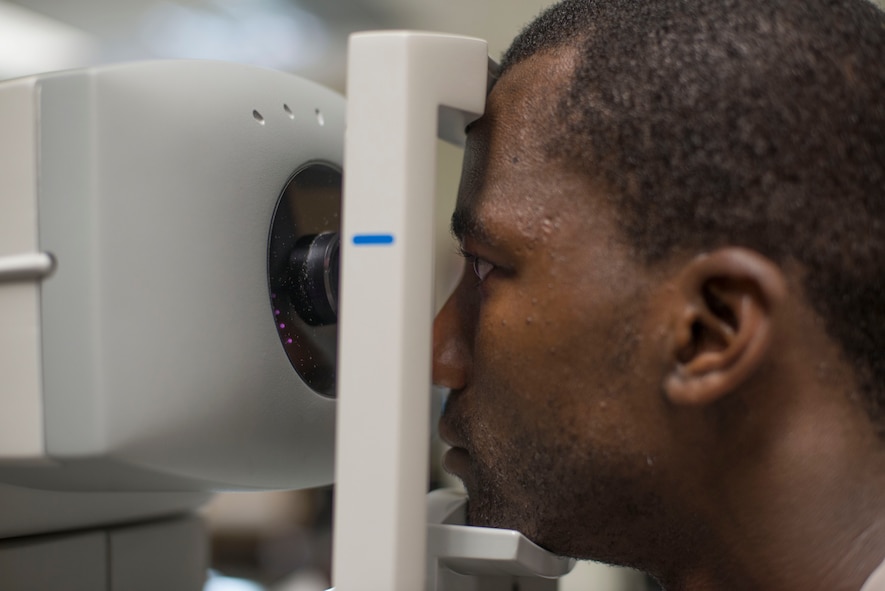 U.S. Air Force Senior Airman Nelson Rolle, 23d Medical Group dental assistant journeyman, looks into an ophthalmometer at the optometry clinic at Moody Air Force Base, Ga., July 28, 2014. The equipment measures how the eye reflects images to check for an astigmatism. (U.S. Air Force photo by Airman 1st Class  Dillian Bamman /Released)