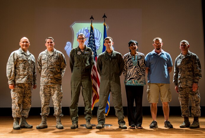 Colonel Jimmy Canlas, 437th Airlift Wing vice commander (left) and Chief Master Sgt. Shawn Hughes, 437th AW command chief (right), congratulate (left to right) Master Sgt. Adam Morgan, Senior Noncommissioned Officer in Charge of the Quarter, Airman 1st Class Stephanie Lucas, Airmen of the Quarter, Staff Sgt. Tyler Wehrung, Noncommissioned Officer in Charge of the Quarter, Faye Ellison, Civilian Category I of the Quarter and Vincent Moseley, Civilian Category II of the Quarter July 24, 2014, during the 437th AW Quarterly Awards ceremony at the Air Base Theater on Joint Base Charleston, S.C. Capt Daniel Naske, Company Grade Officer of the Quarter was unable to attend the ceremony. (U.S. Air Force photo/ Senior Airman Dennis Sloan)