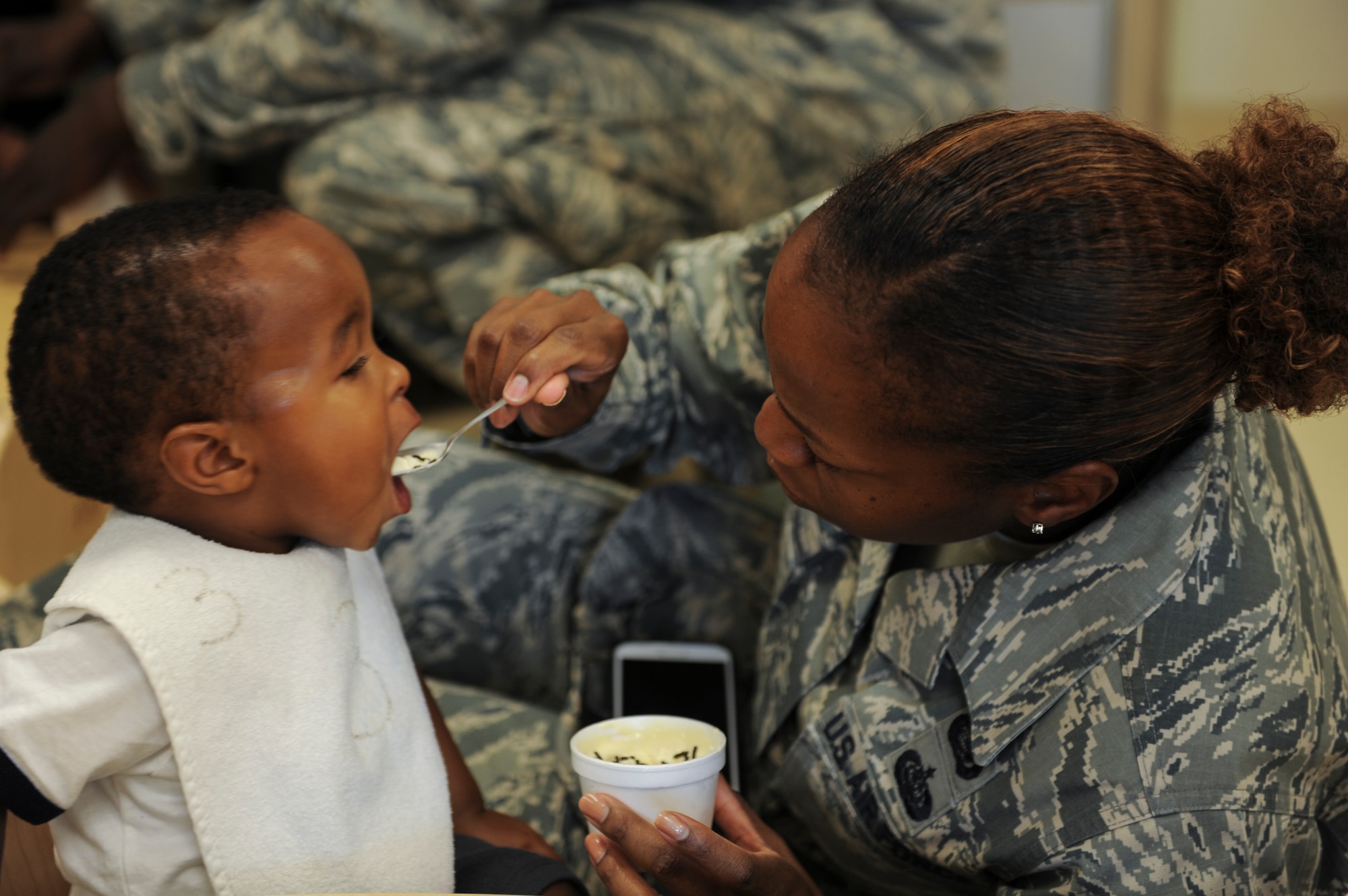 U.S. Air Force Tech Sgt. Myisha Marks, 23d Wing Equal Opportunity NCO in charge, feeds her son Derell a bite of ice cream at Moody Air Force Base, Ga., July 25, 2014. All parents of children enrolled in the Child Development Center were invited to participate in an ice cream social to encourage parent involvement. (U.S. Air Force photo by Airman 1st class Alexis Millican/Released)