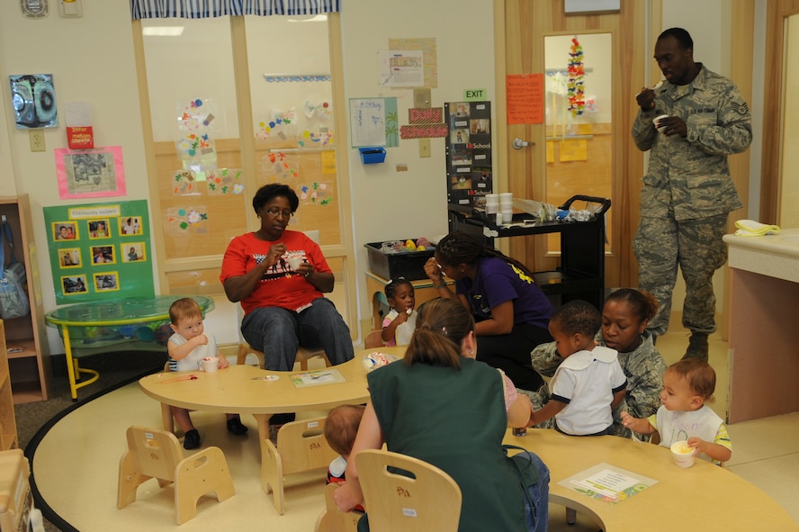 Teachers, parents and children from the Child Development Center II eat ice cream during an ice cream social at Moody Air Force Base, Ga., July 25, 2014. Parents were invited to attend the social and enjoy ice cream with their child. (U.S. Air Force photo by Airman 1st class Alexis Millican/Released)