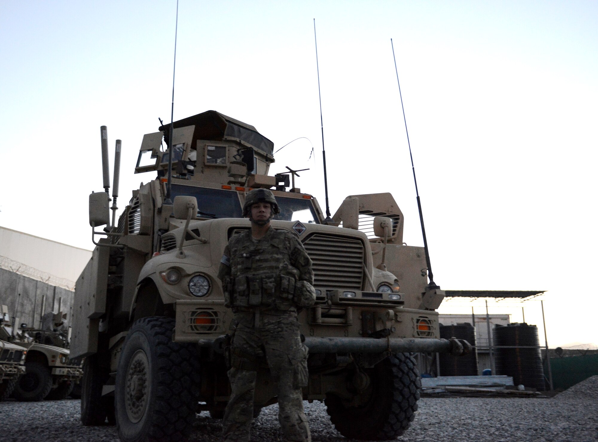 Senior Airman Julian Rangel stands by one of the mine-resistant ambush-protected vehicles that two Air Force quick reaction forces used while defending a forward operating base from a Taliban attack July 17 near Kabul Airport and Afghan air force base, Afghanistan. Rangel, who was asleep at the time the attack began, responded to the fight in shorts, t-shirt and tennis shoes under his body armor. He served as a gunner on the vehicle and laid down about 400 rounds of suppressive fire with an M240B medium machine gun during the more than four-hour firefight. (U.S. Air Force photo/Senior Master Sgt. Mike Hammond)