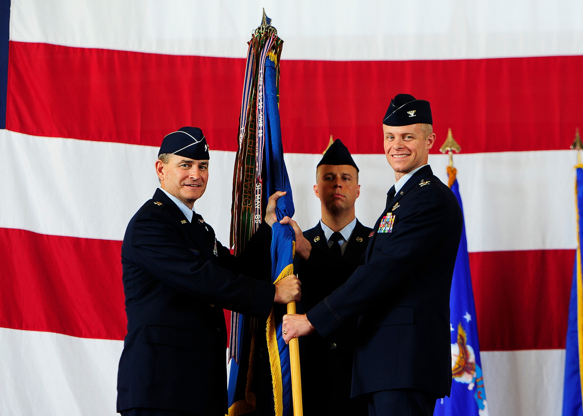 Major Gen. H. D. Polumbo, Jr., Ninth Air Force commander, passes the 325th Fighter Wing guidon to Col. Derek C. France, during the 325th Fighter Wing change of command ceremony, July 24, 2014, at Tyndall AFB, Fla. (U.S. Air Force photo by Technical Sgt. Javier Cruz/Released)