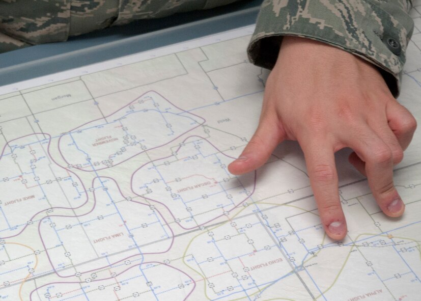 Senior Airman Gregory Nelson, 90th Operations Support Squadron, explains the uses of a map of F.E. Warren Air Force Base’s missile complex in the weather office July 24, 2014. A map of the missile complex allows the weather unit to notify leadership of weather issues so they may better plan operations. (U.S. Air Force photo by Airman Malcolm Mayfield)