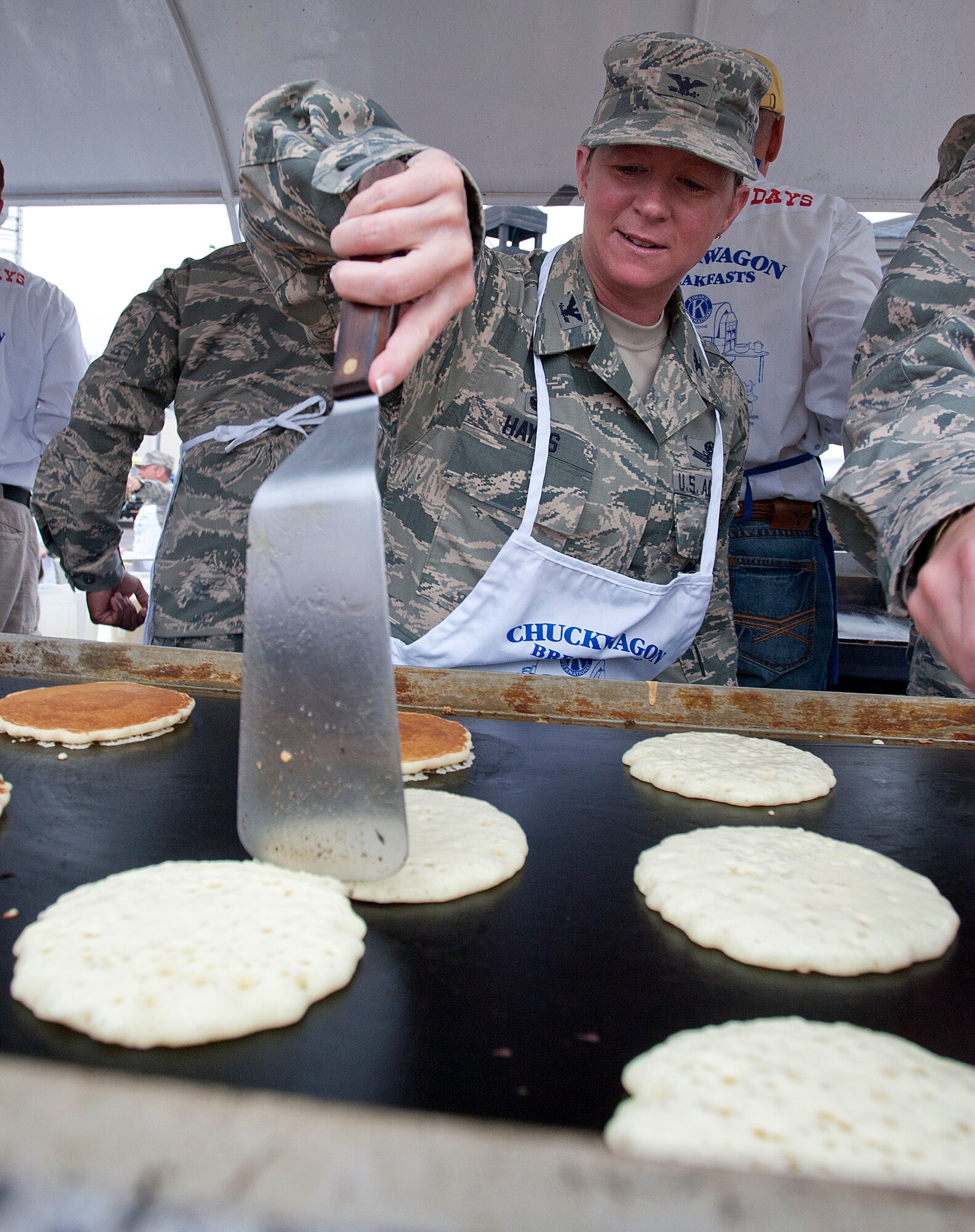 Col. Tracey Hayes, 90th Missile Wing commander, works the griddle in Depot Plaza, Cheyenne, Wyo., July 23, 2014. Free pancake breakfasts, feeding thousands of visitors, are a tradition during the annual Cheyenne Frontier Day festivities, with local organizations volunteering to handle the spatulas. (U.S. Air Force photo by R.J. Oriez) 