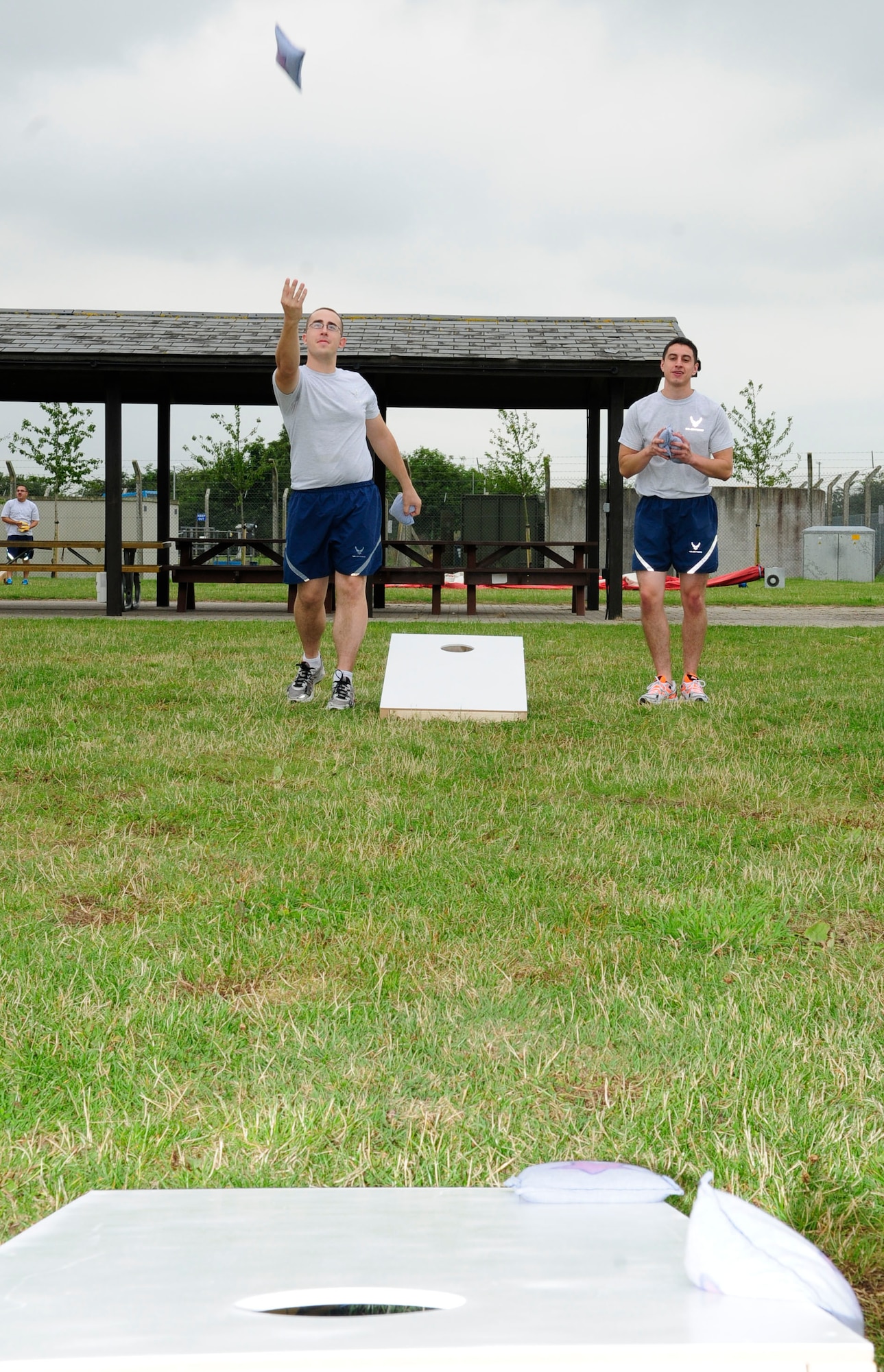 U.S. Air Force Senior Airman John Vacca, left, 100th Aircraft Maintenance Squadron refueling aerospace maintenance journeyman from Baltimore, Md., throws a beanbag during a game of cornhole at the 100th Maintenance Group sports day July 21, 2014, on RAF Mildenhall, England. The 100th MXG Airmen and families participated in various sports events, which were followed by a barbecue to build morale within the group and foster a family environment. (U.S. Air Force photo/Karen Abeyasekere/Released)