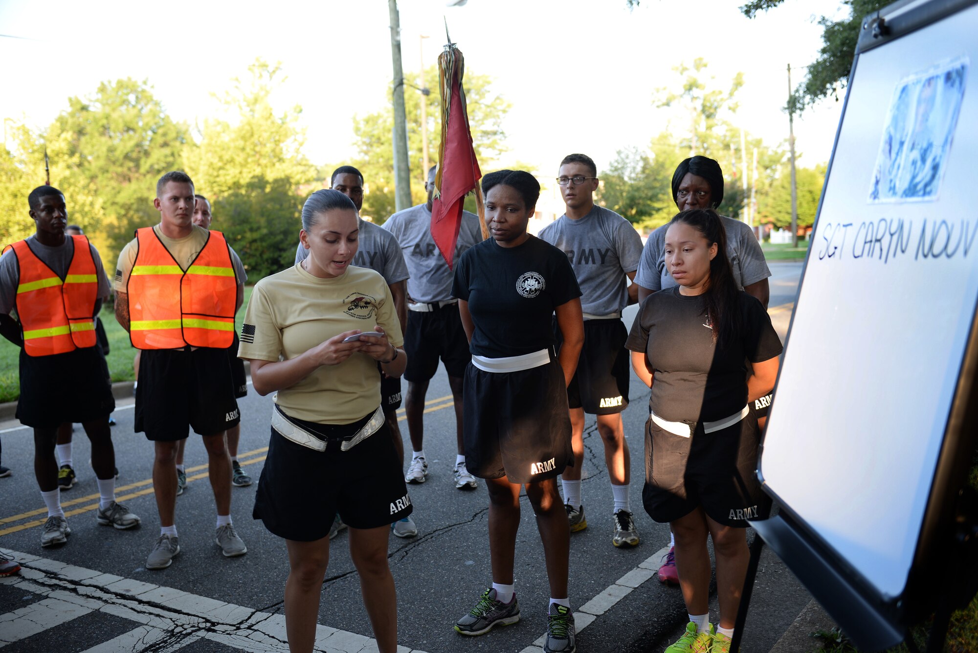 U.S. Army Sgt. Melissa Raposo, 2nd Platoon, 359th Inland Cargo Transfer Company, 10th Transportation Battalion, 7th Transportation Brigade (Expeditionary) squad leader, reads a quote from a poem for a fallen Soldier during a memorial 5K run at Fort Eustis, Va., July 25, 2014. Soldiers read from “Do Not Stand at My Grave and Weep,” by Mary Elizabeth Frye at each mile marker in honor of three  fallen comrades. (U.S. Air Force photo by Senior Airman Teresa J.C. Aber/Released)
